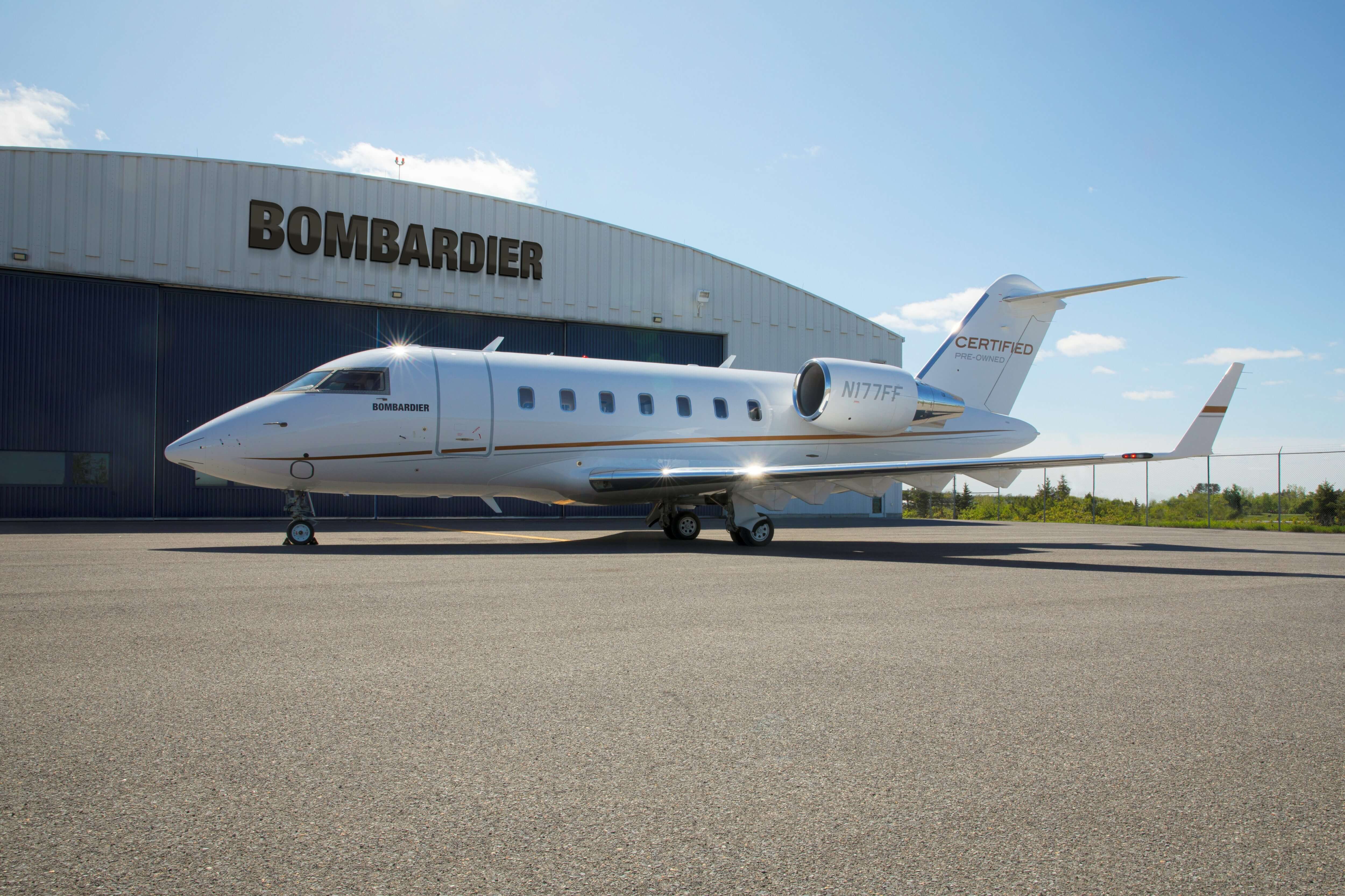 A Bombardier Challenger 605 parked outside a hangar.