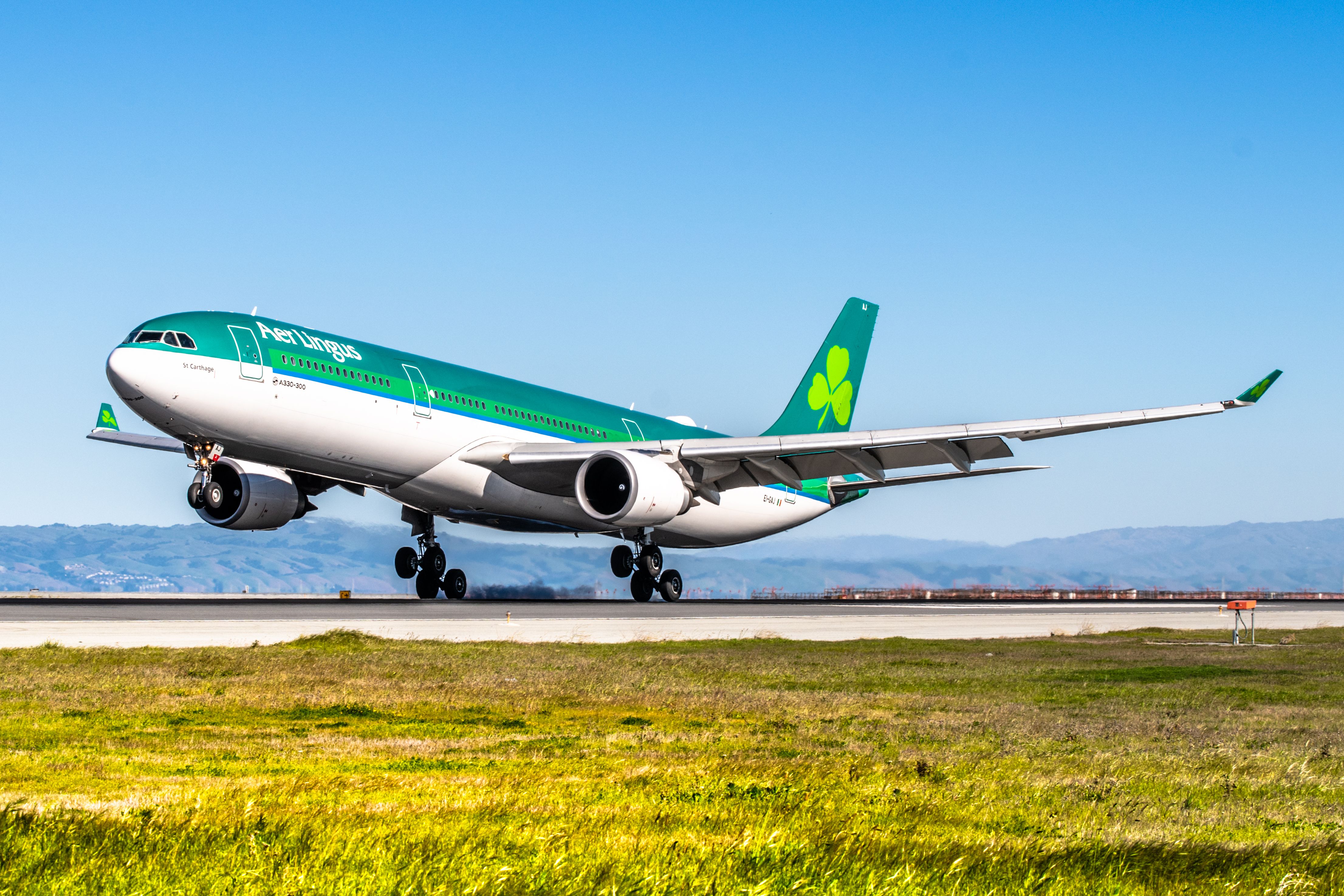 An Aer Lingus Airbus A330-302 just above a runway.