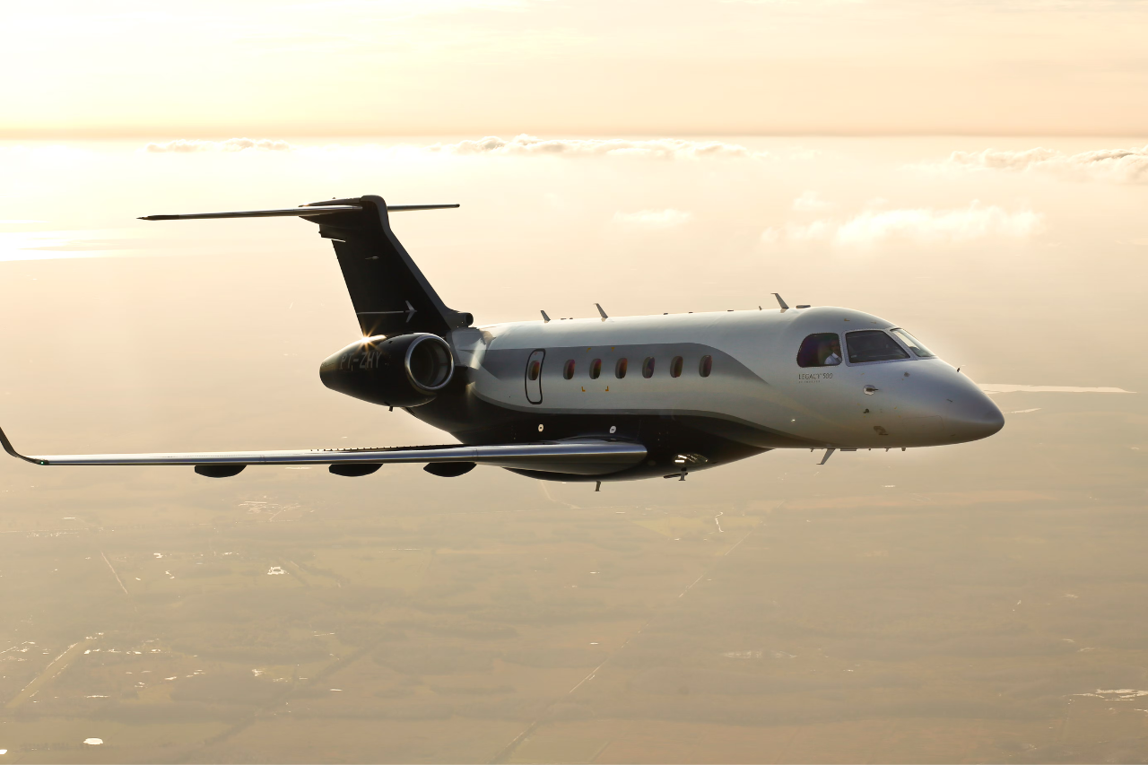 An mbraer Legacy 500 flying at dusk.