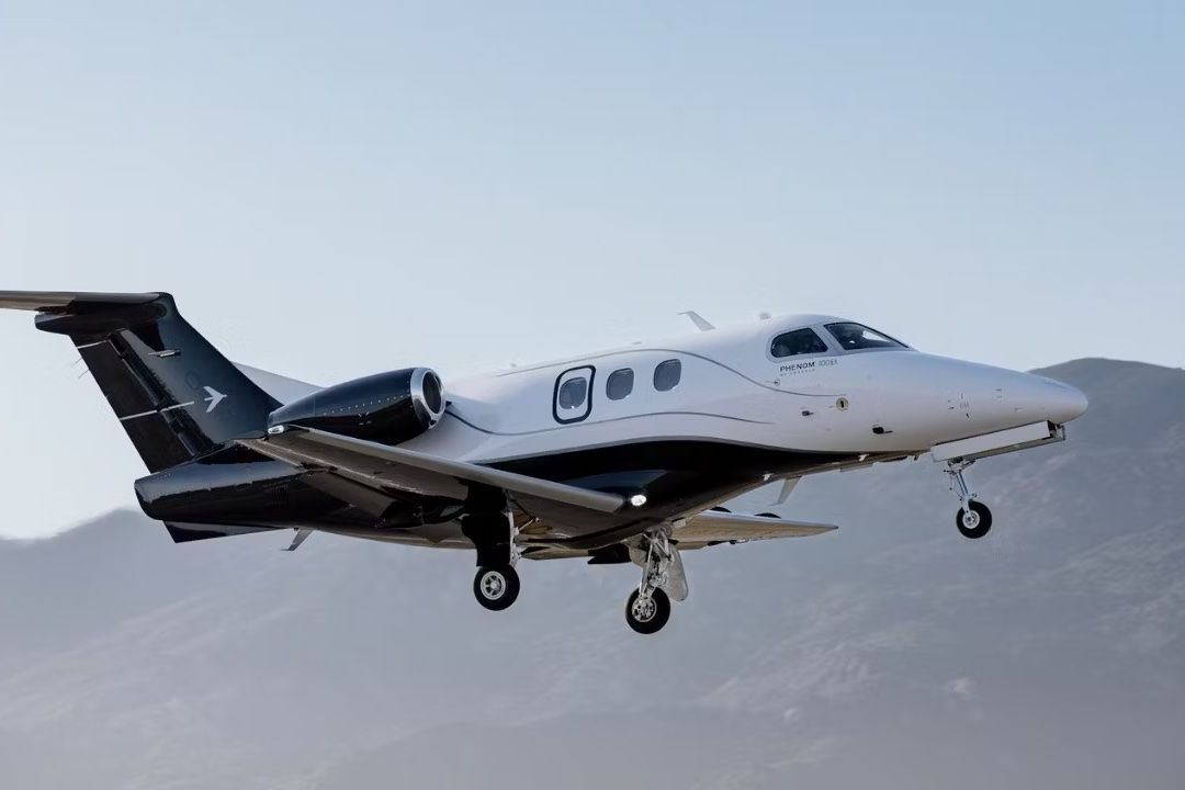 An Embraer Phenom 100 flying in the sky.
