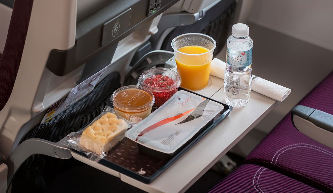 A tray featuring Qatar Airways economy class food. 