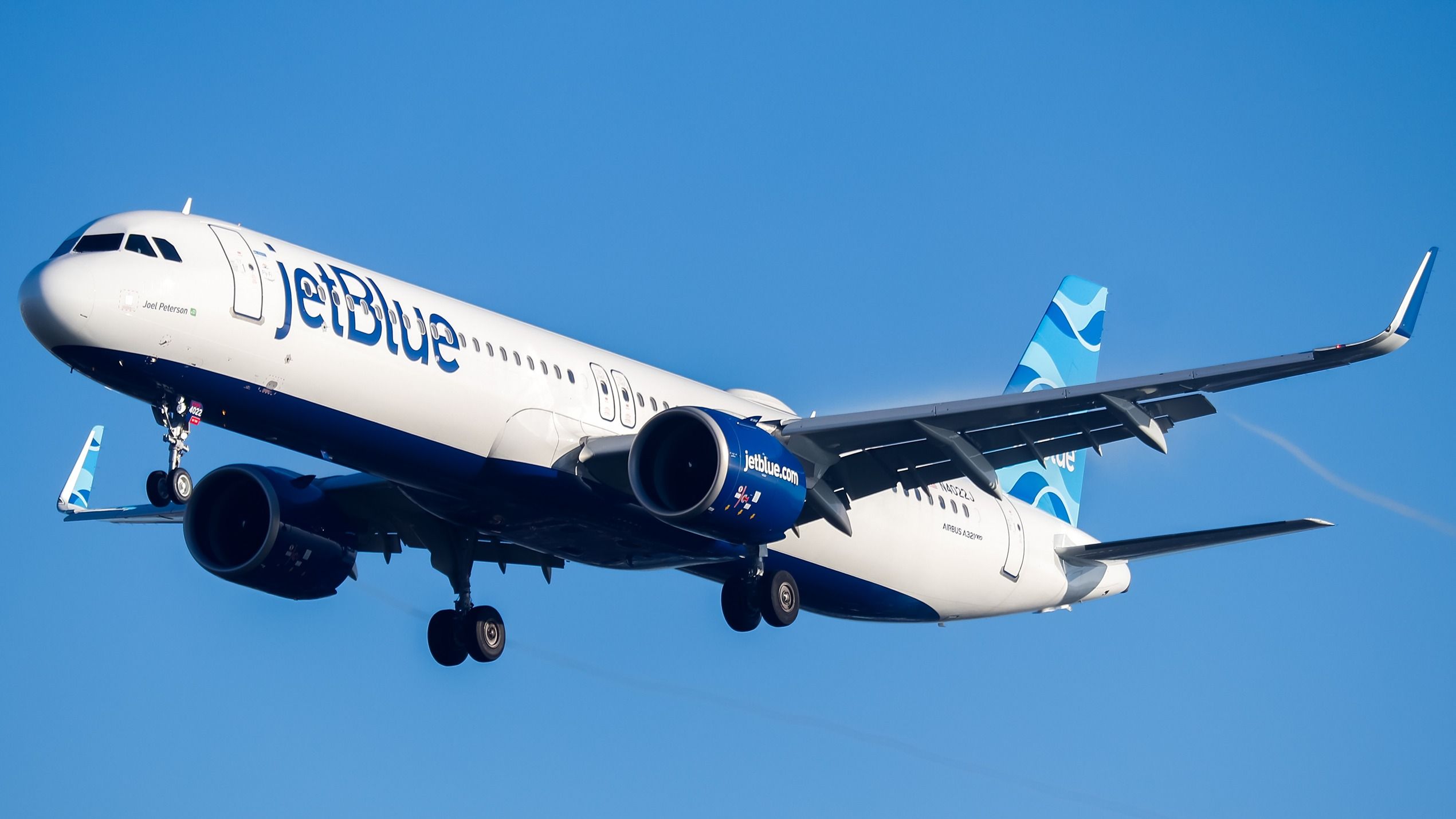 A JetBlue Airbus A321LR flying in the sky.