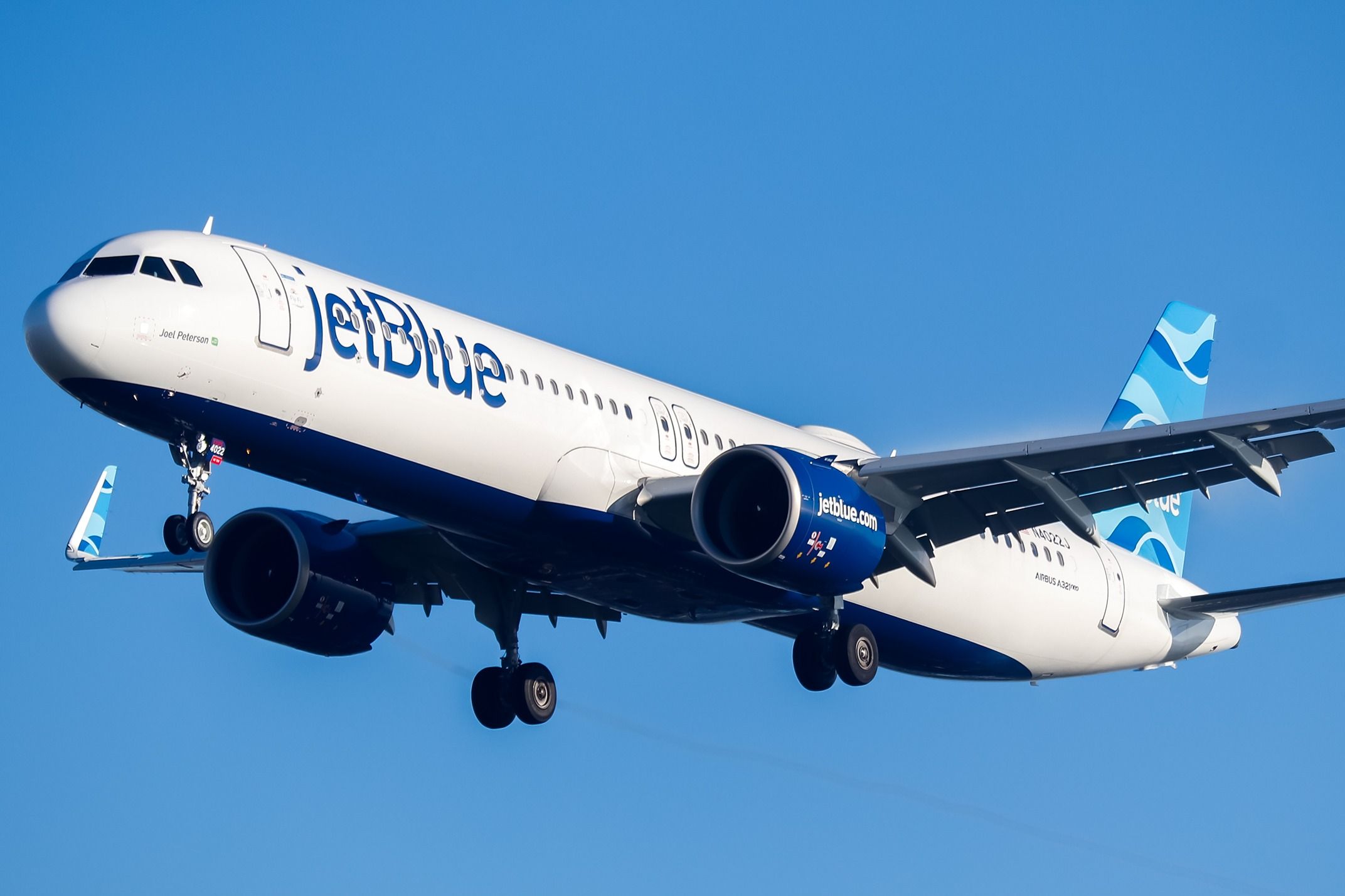 A JetBlue Airbus A321LR flying in the sky.