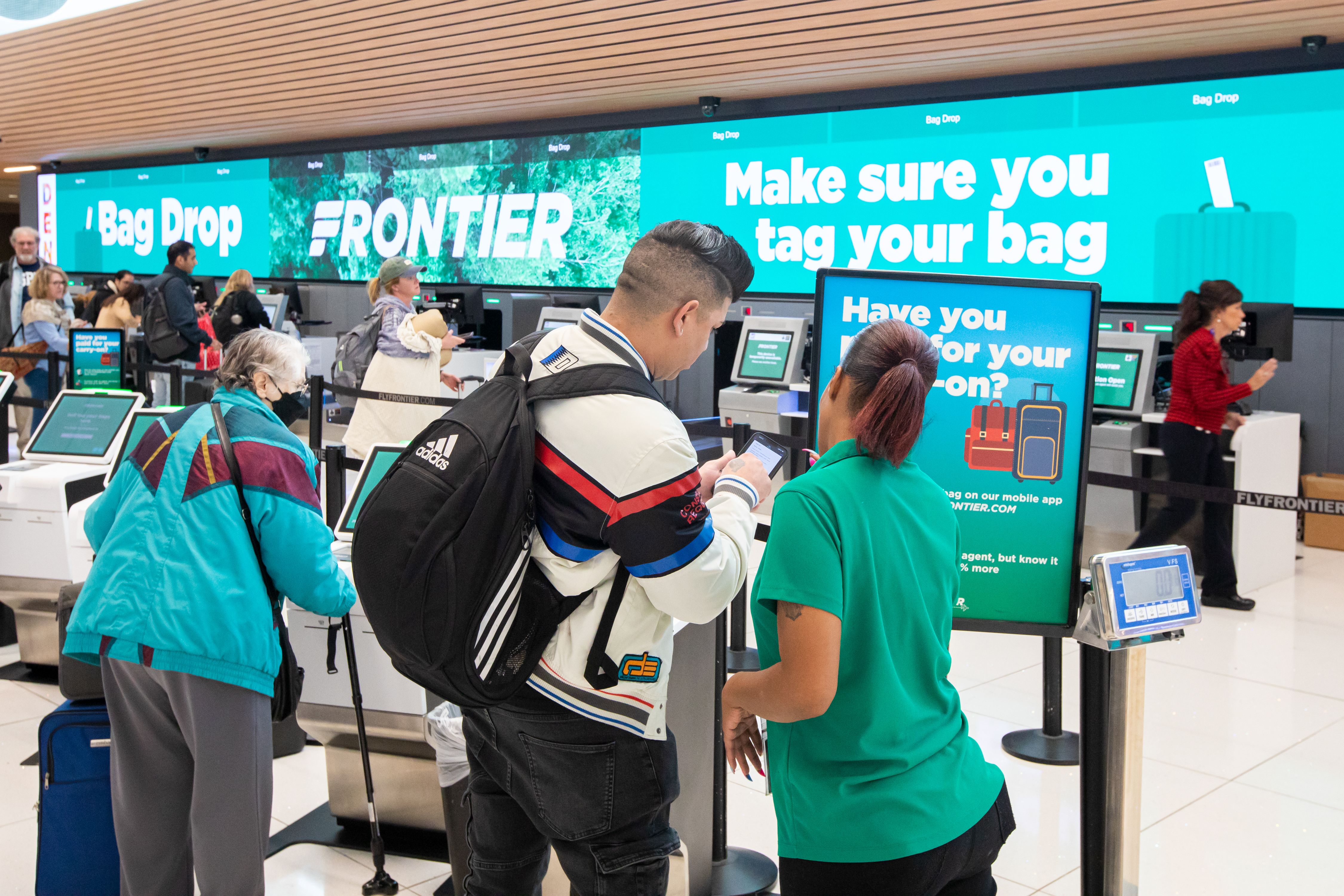 Passengers checking in for a Frontier Airlines flight.