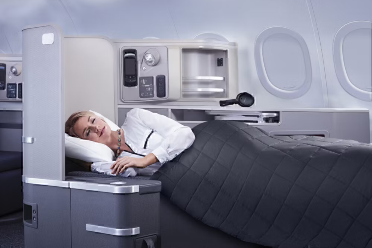 A Passenger lying down in the American Airlines Flagship First seat.