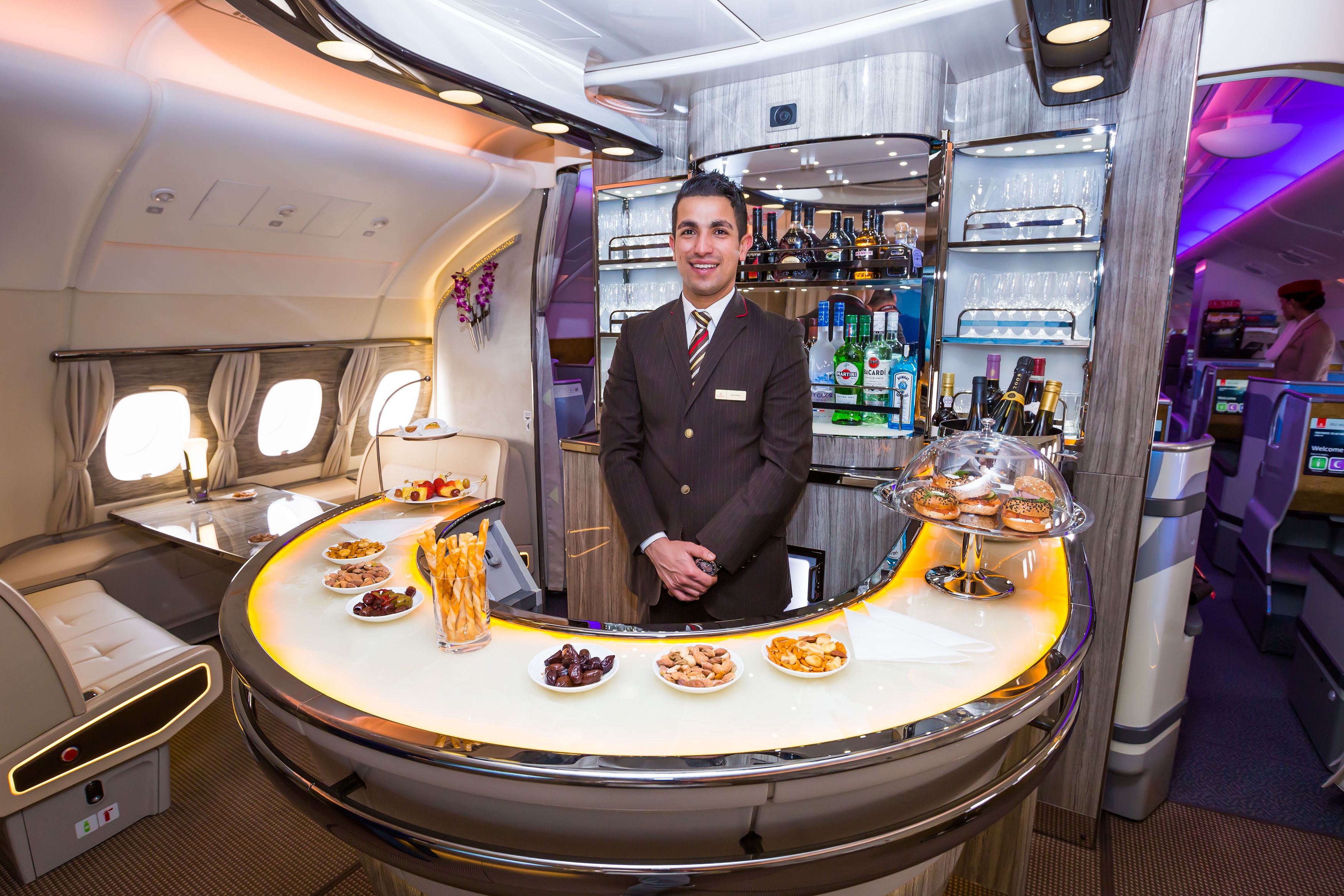 A bartender standing behind the bar of an Emirates Airbus A380.
