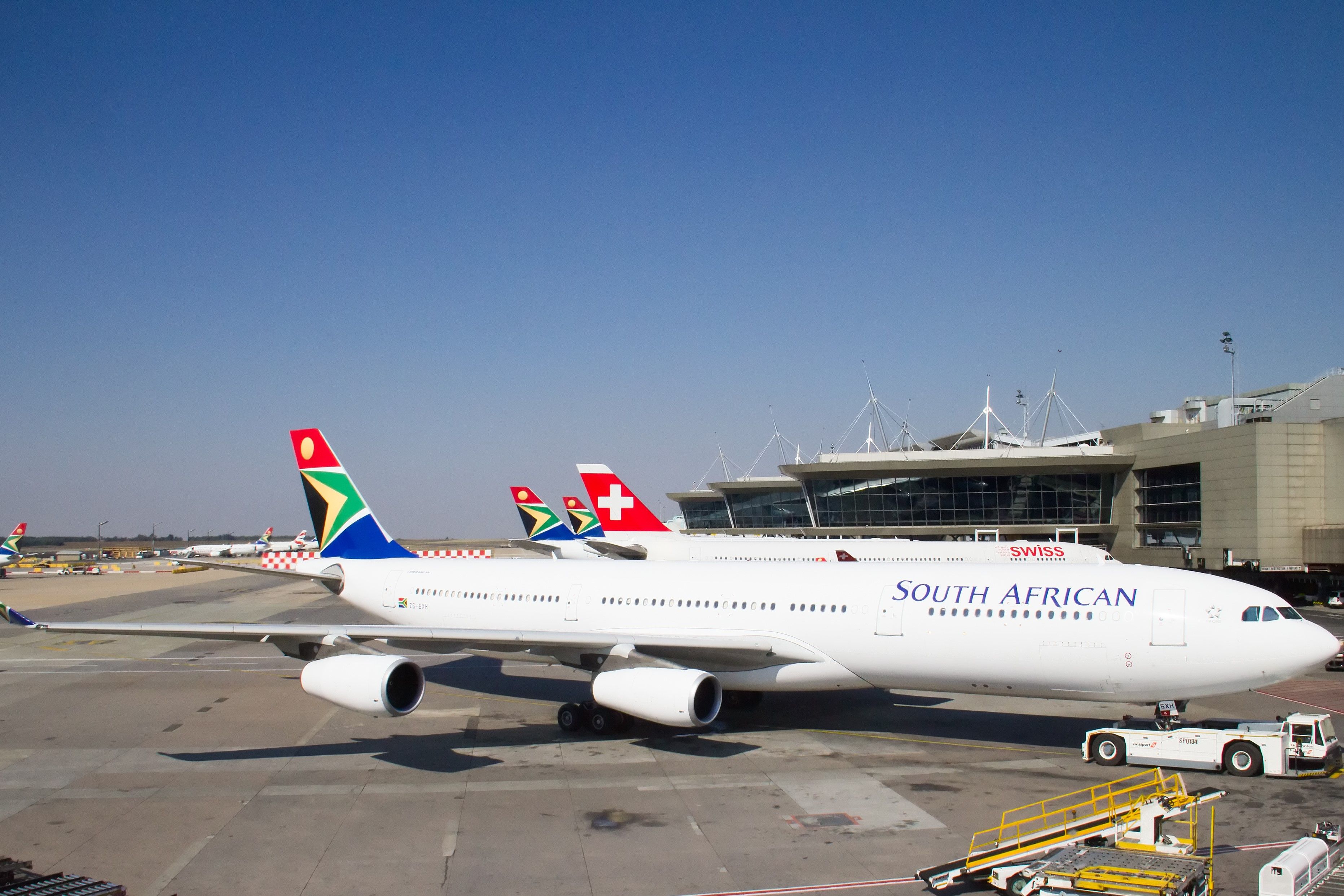 A South African Airways aircraft parked near a SWISS aircraft on an airport apron.