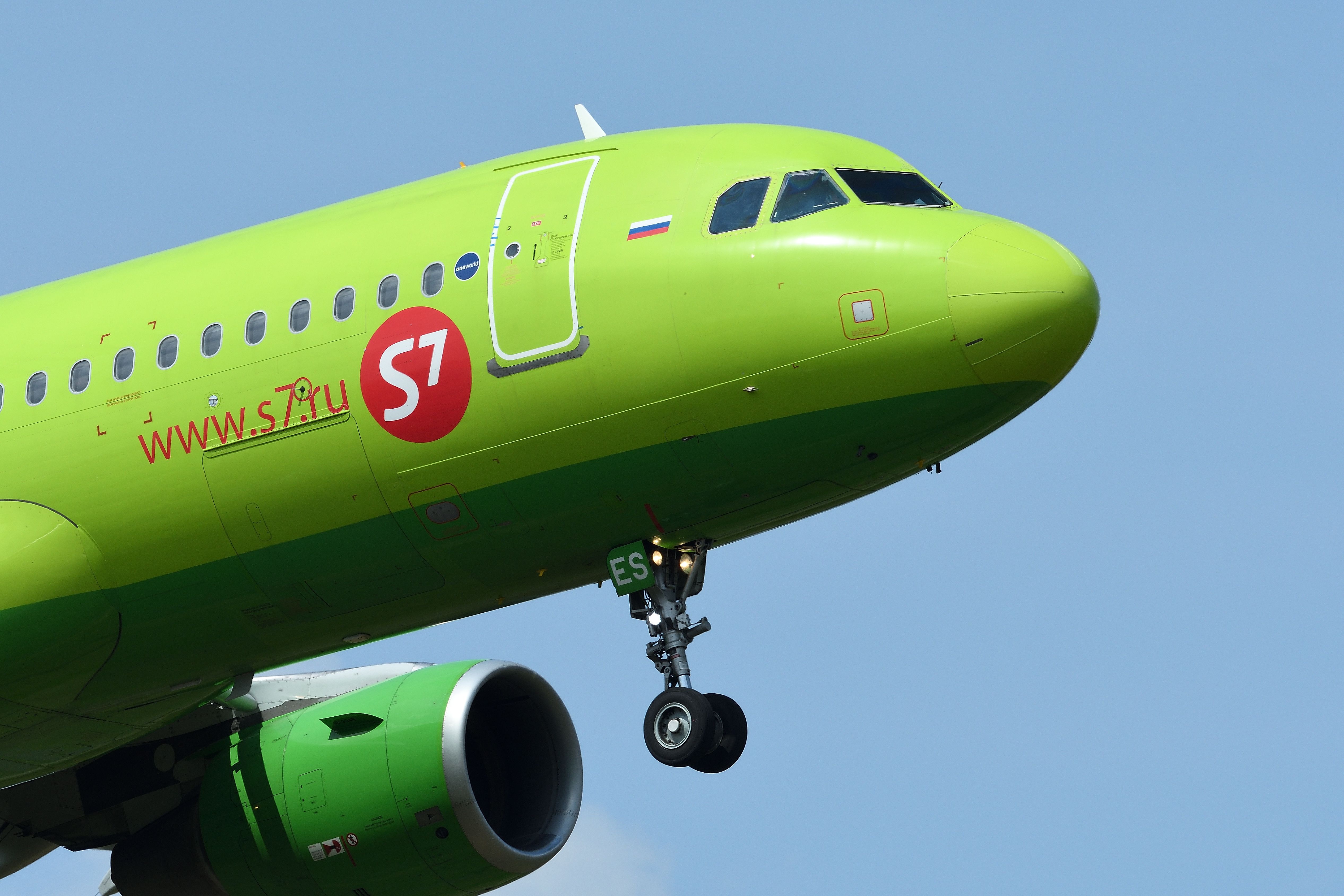 A closeup of the nose of an S7 Airlines Airbus A320 flying in the sky.