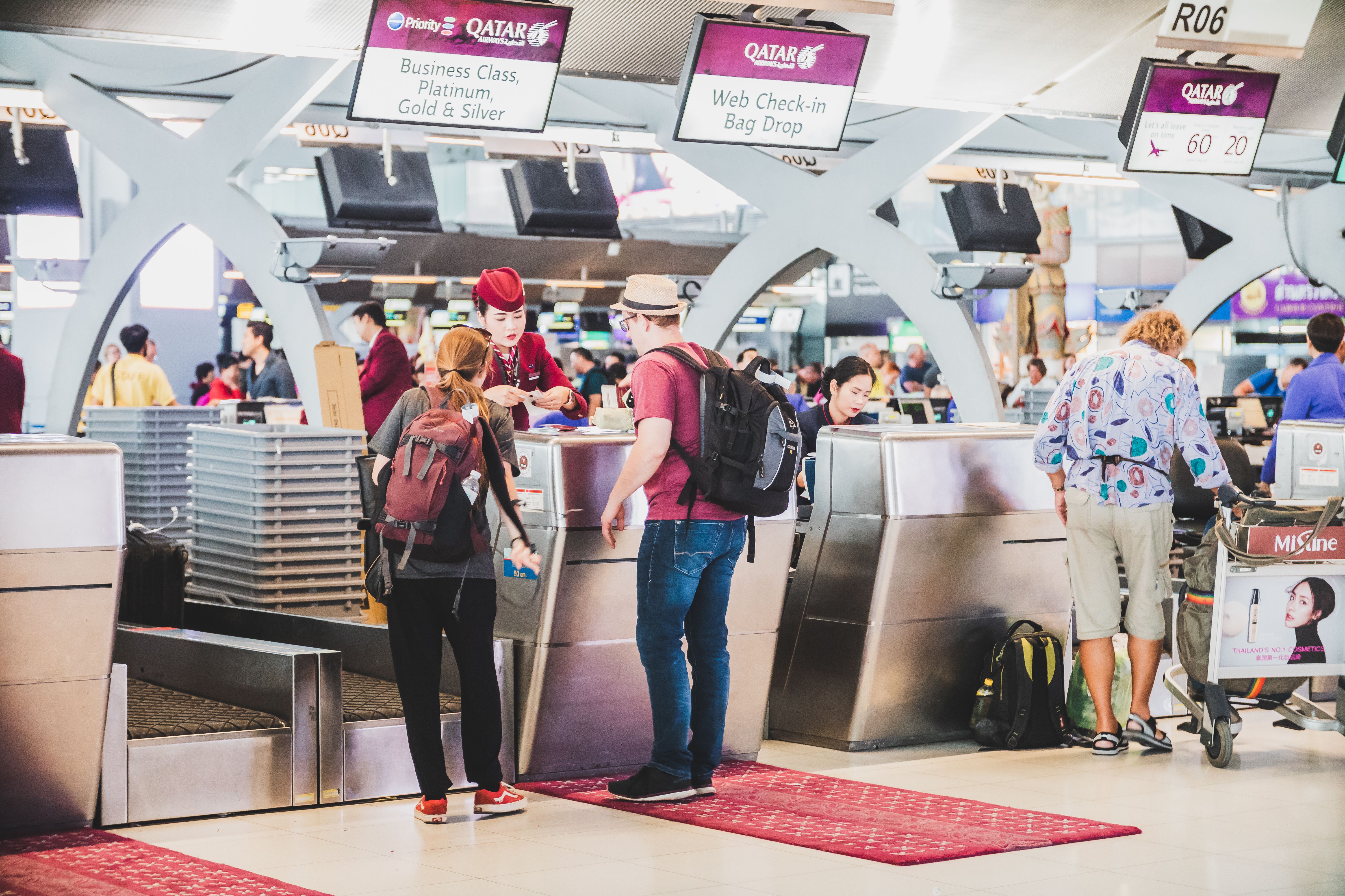 Passengers checking in at the Qatar Airways check-in desk.