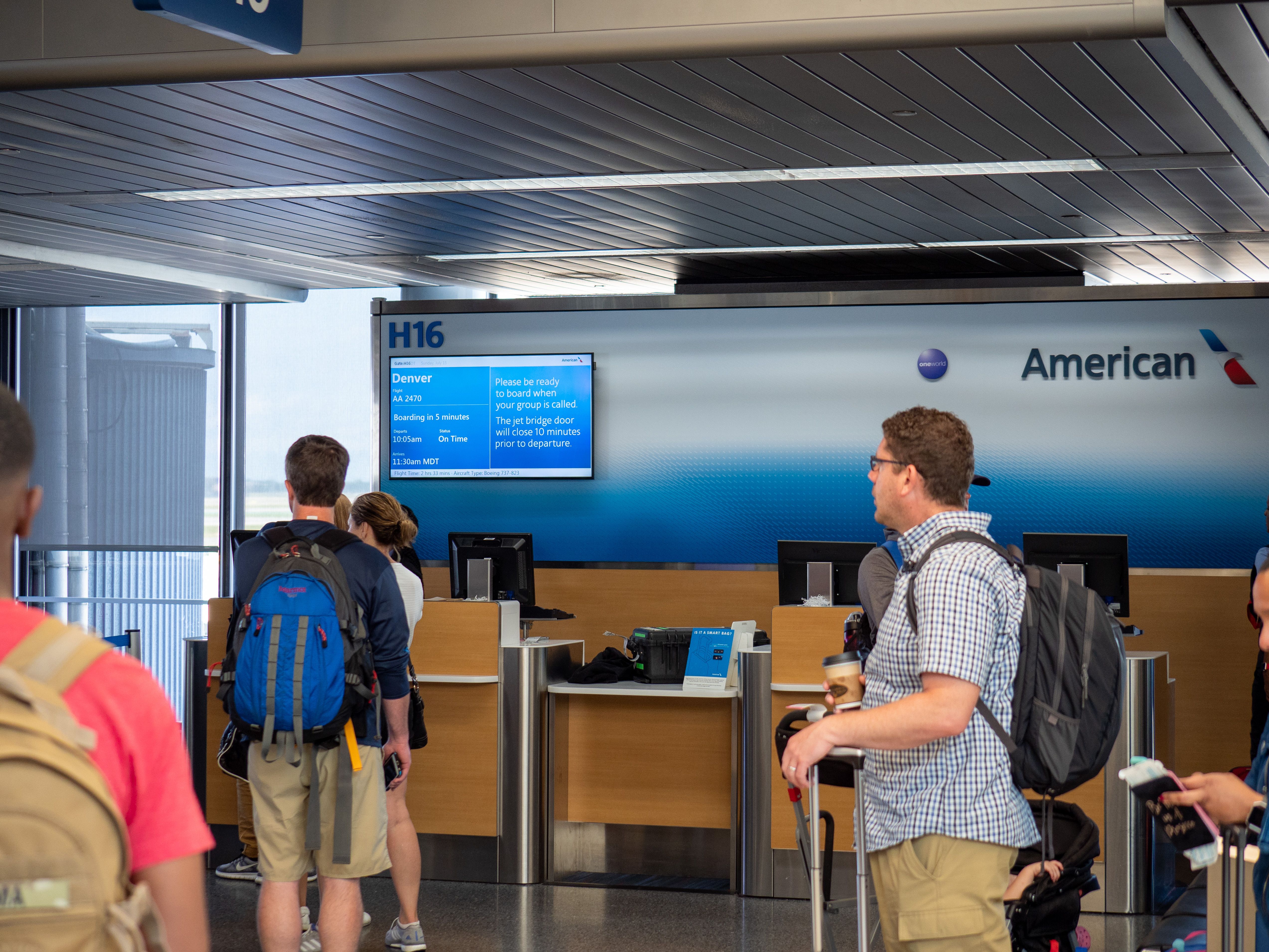 Several passengers at a gate waiting for an American Airlines flight.