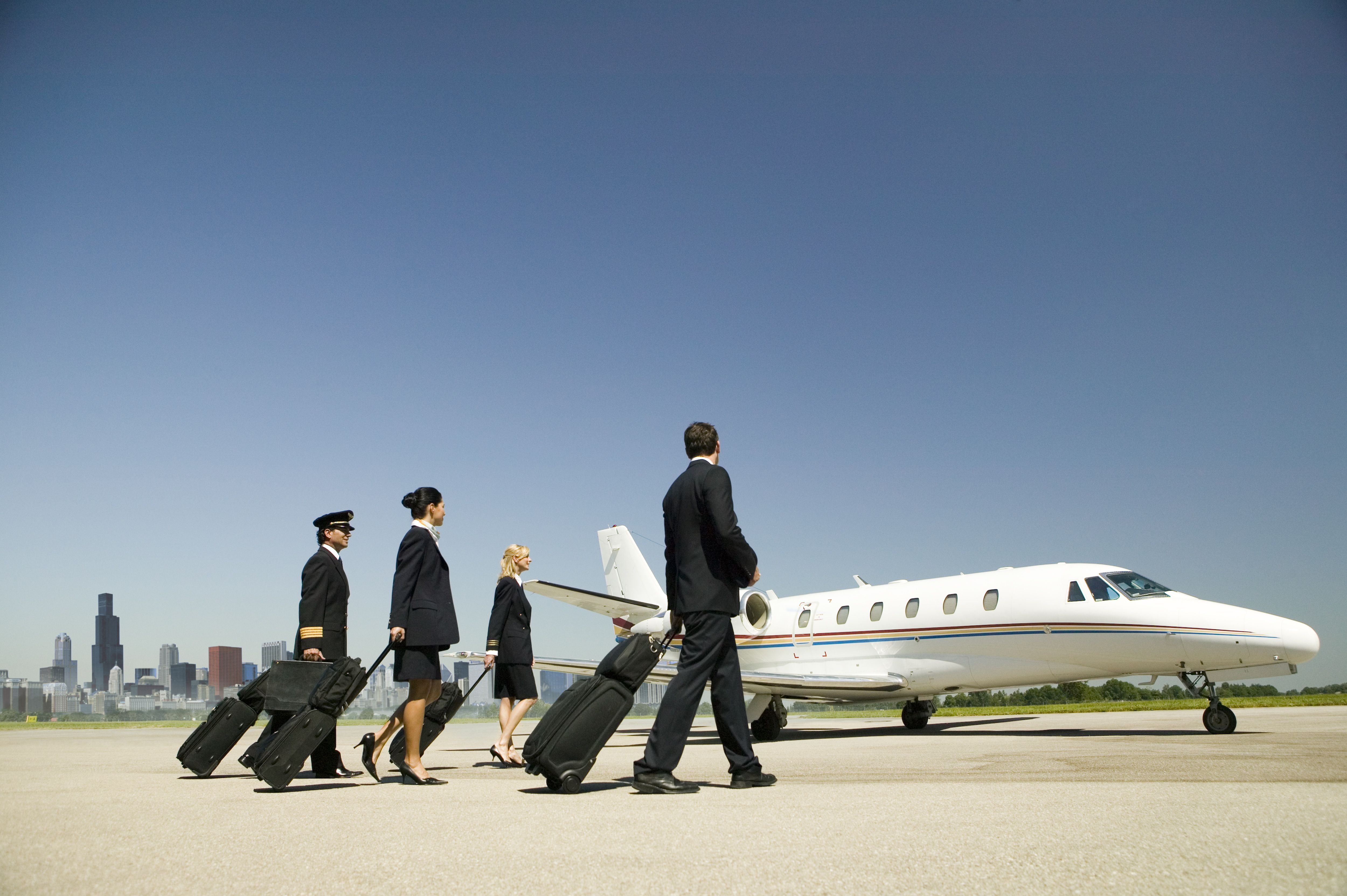 Several Flight and cabin crew walking towards a private jet.