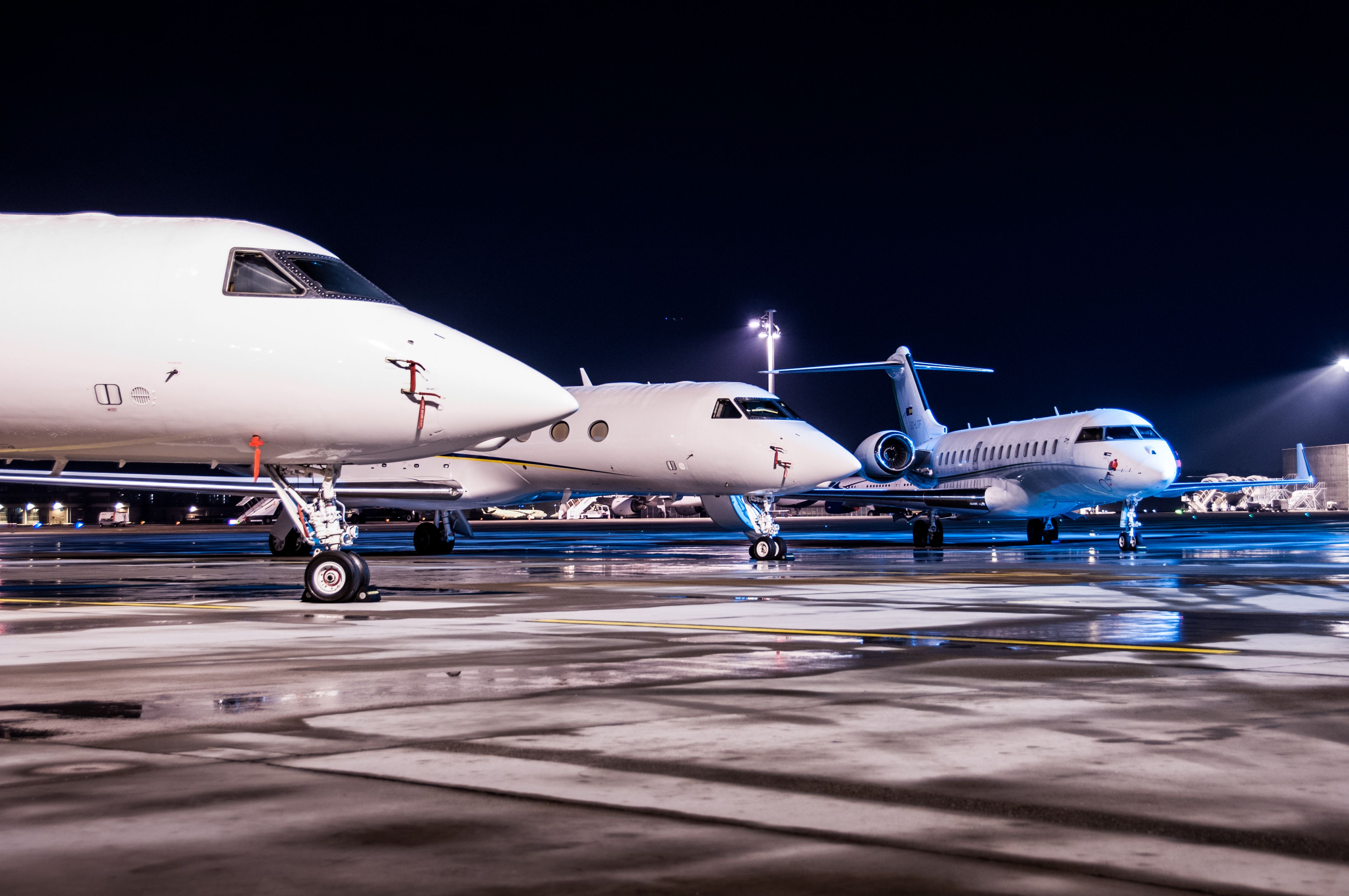 Several Private jets parked on an airport apron.