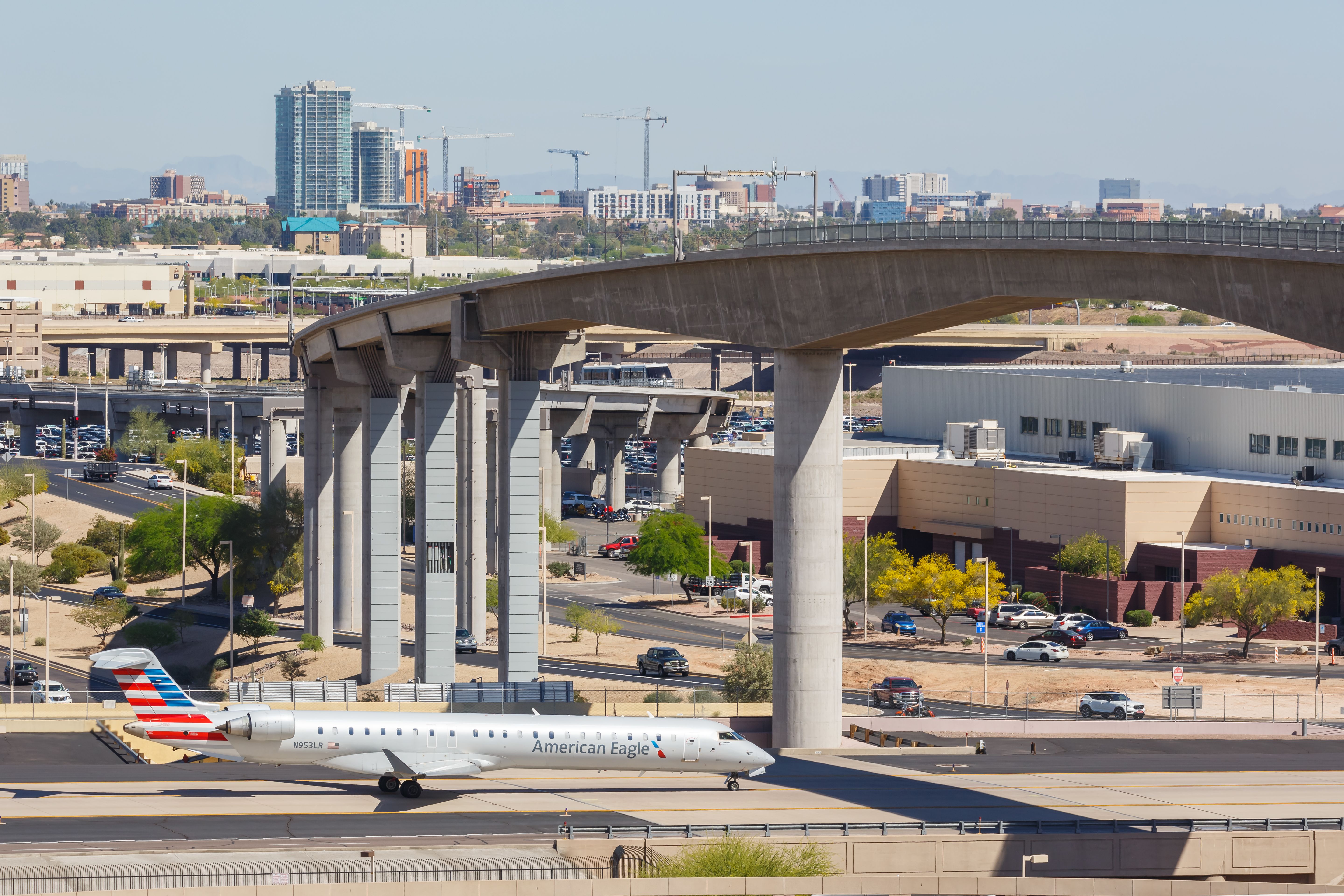 American Eagle (Mesa Airlines) Bombardier CRJ-900 (N953LR) taxiing at Phoenix Sky Harbor International Airport under the PHX Sky Train bridge.