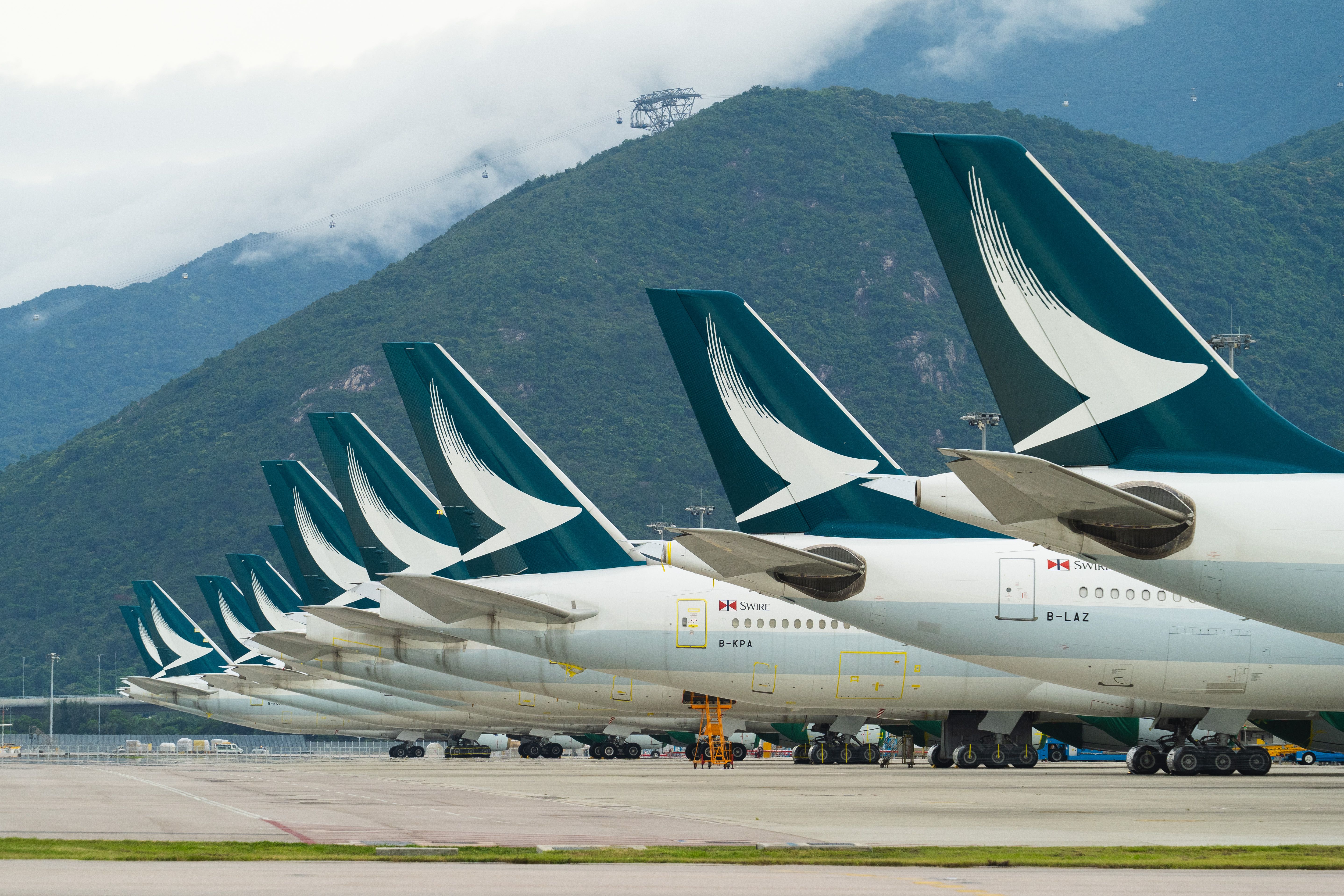 A fleet of Cathay Pacific airplanes parked side by side.