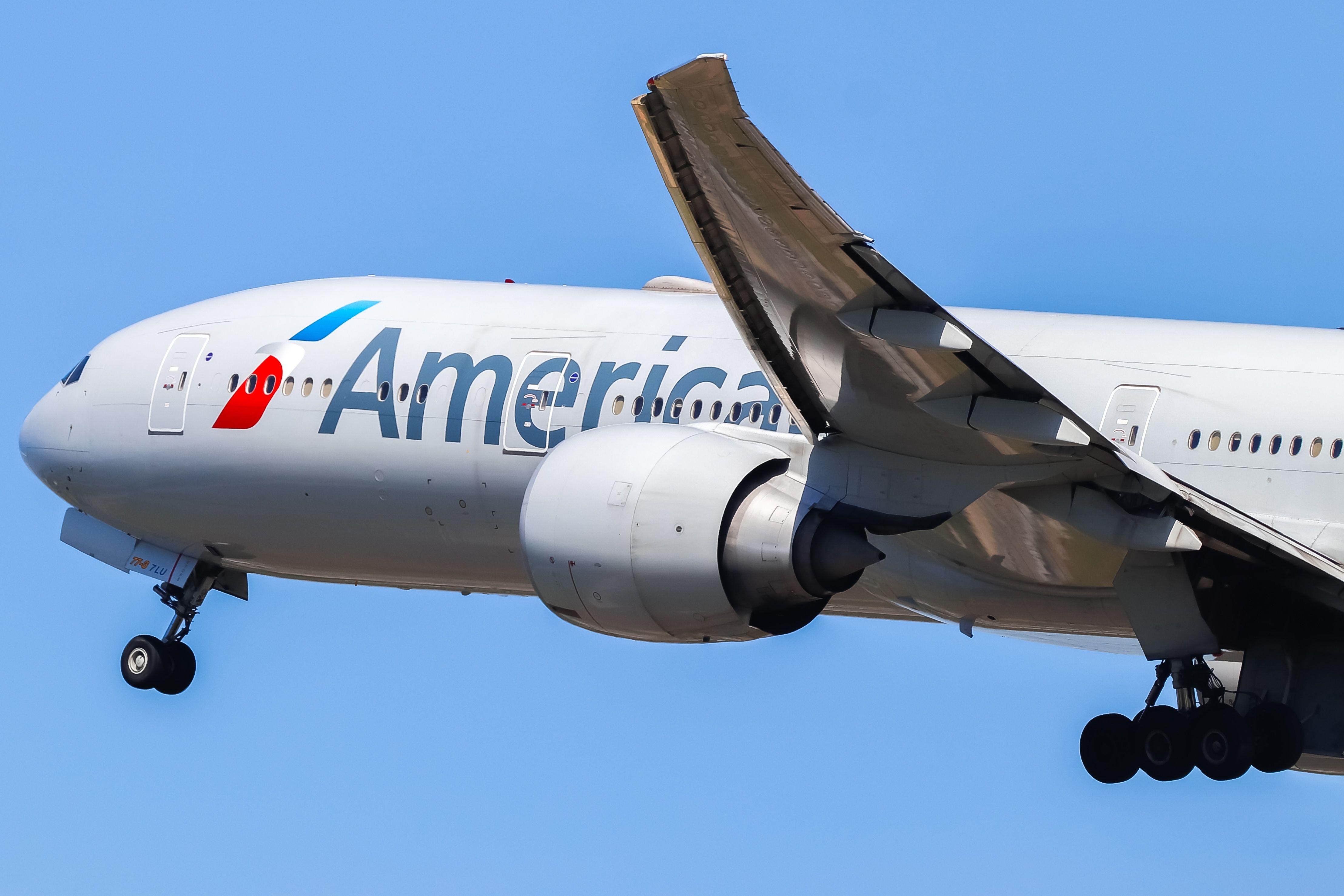 An American Airlines Boeing 777-300ER flying in the sky.