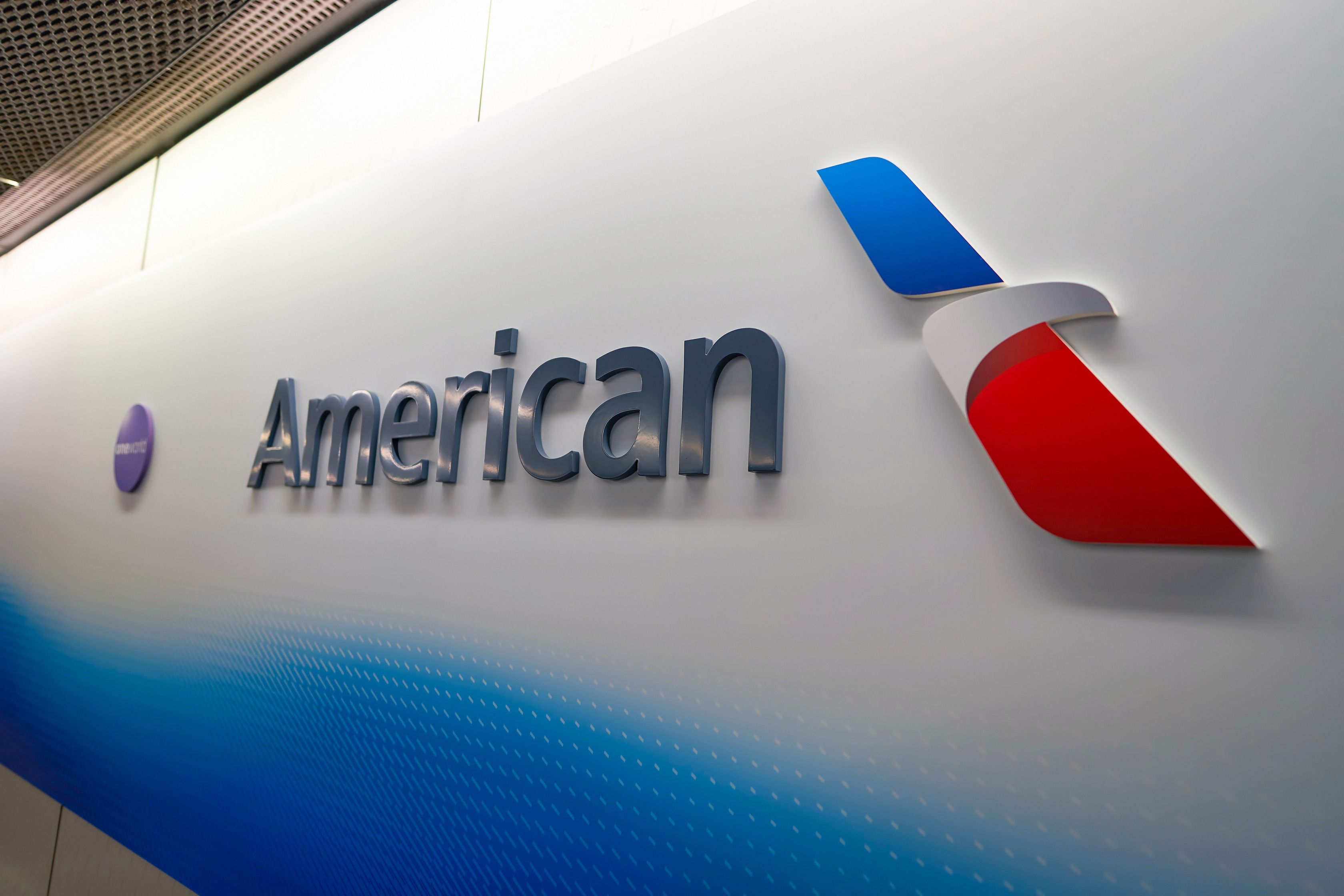 An American Airlines logo near the check in area at an airport.