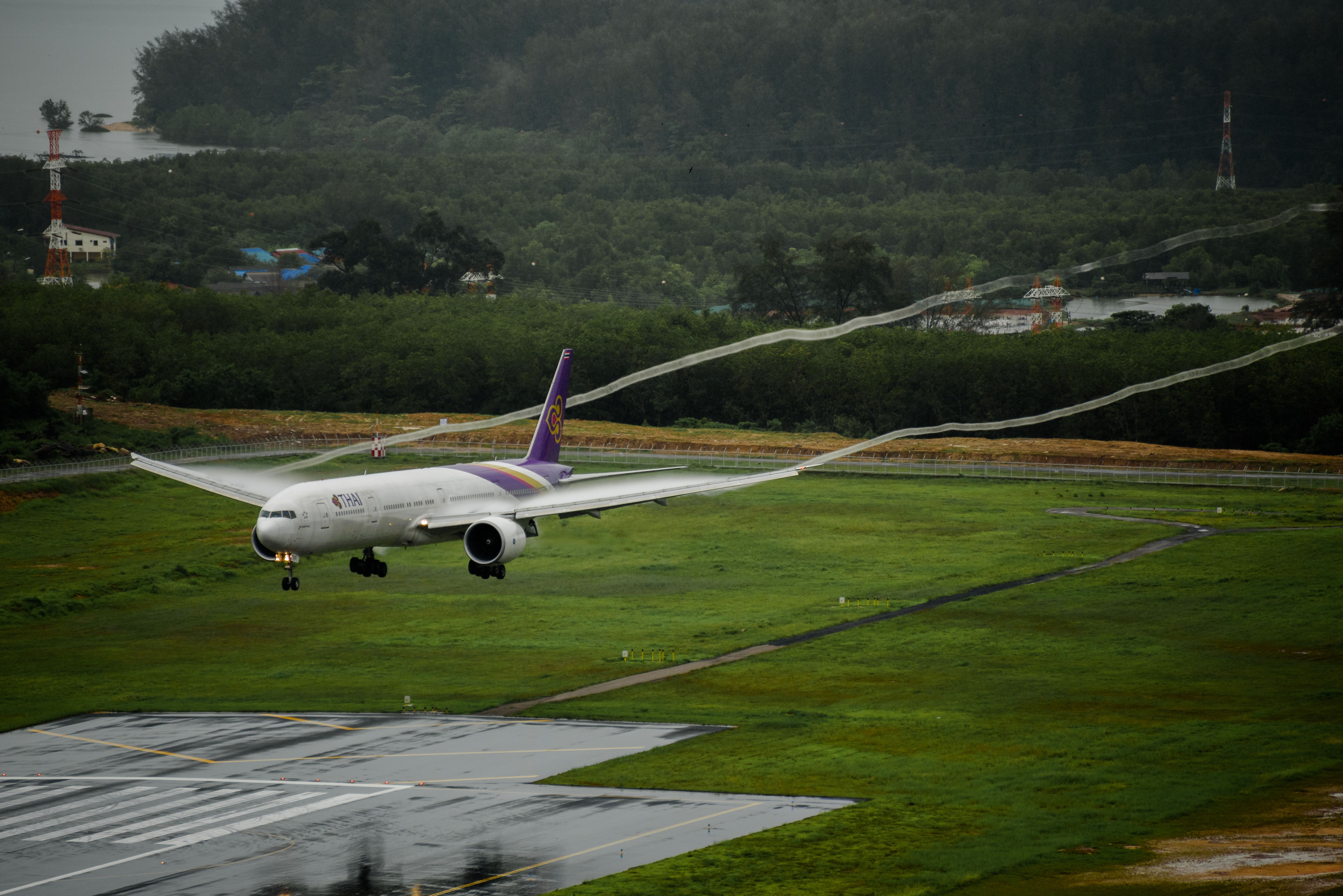 A Thai Airways aircraft about to land on a humid day in Thailand.