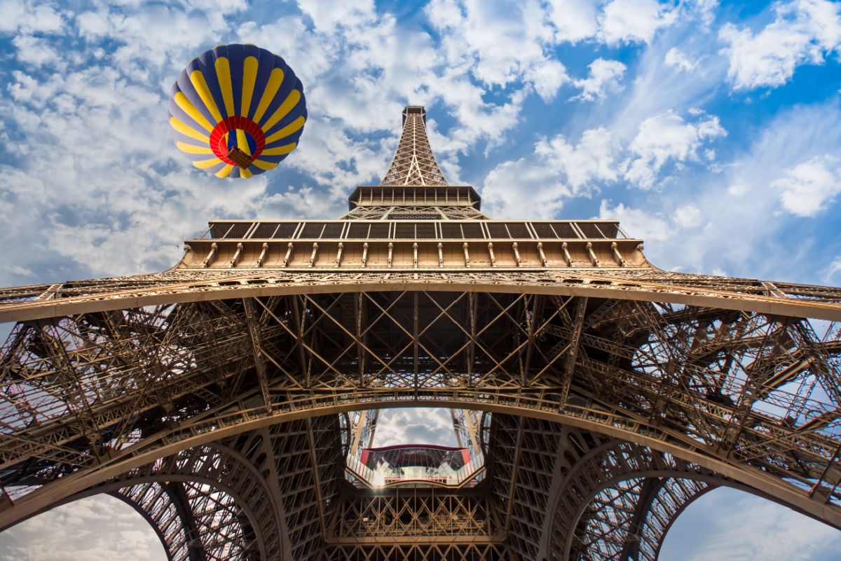 A Hot air balloon flying over the Eiffel tower.