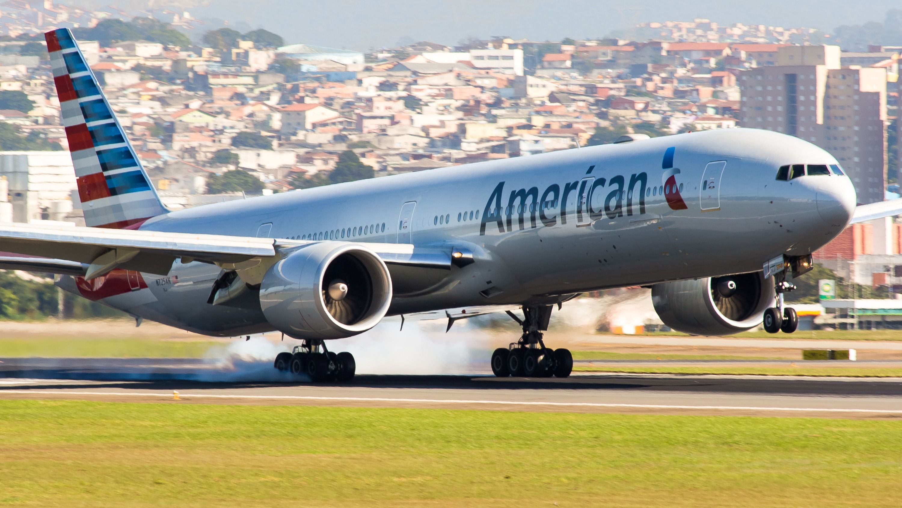 An American Airlines Boeing 777-300ER landing on a runway.