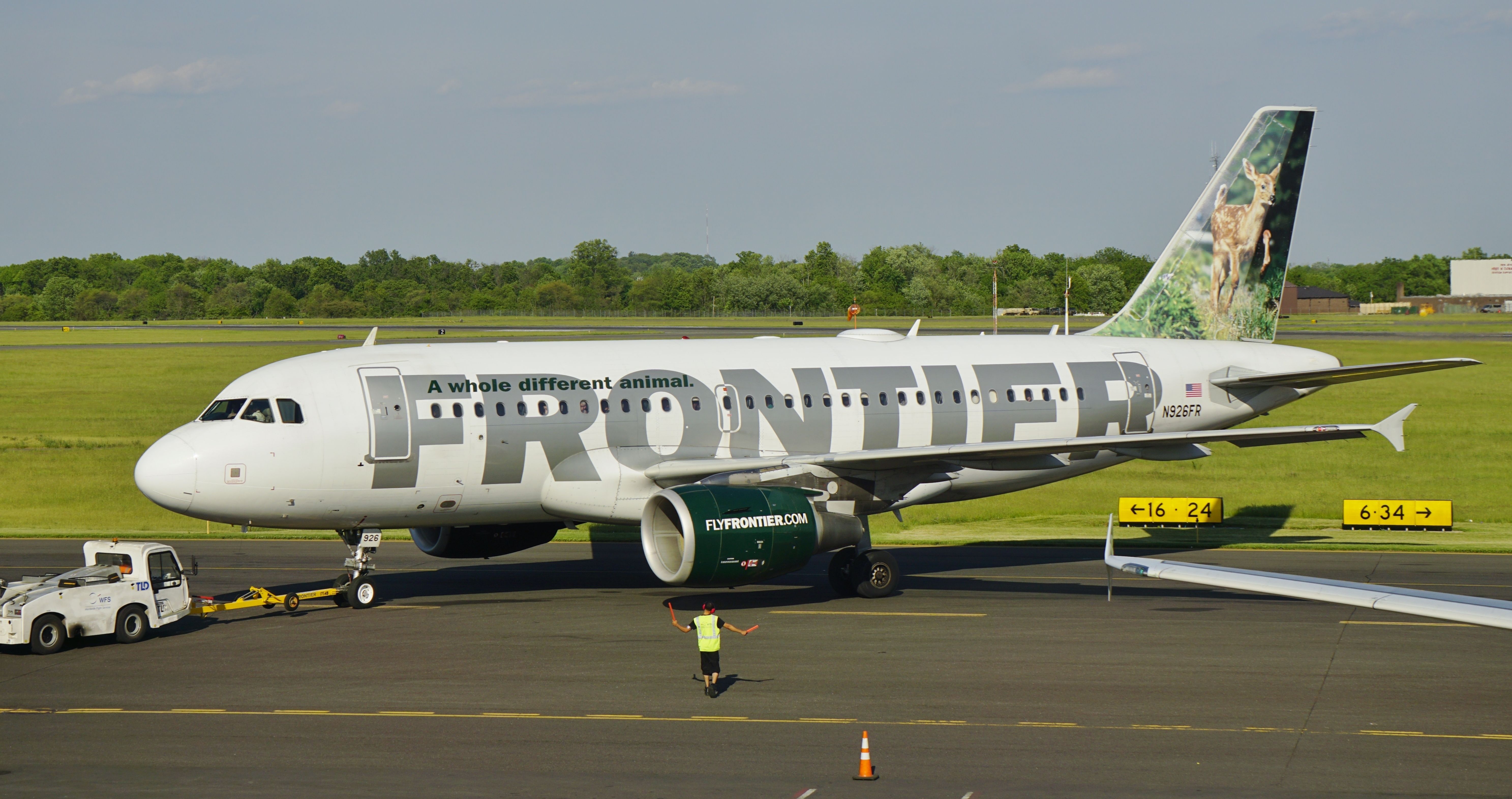 An old Frontier Airlines aircraft on an airport apron.