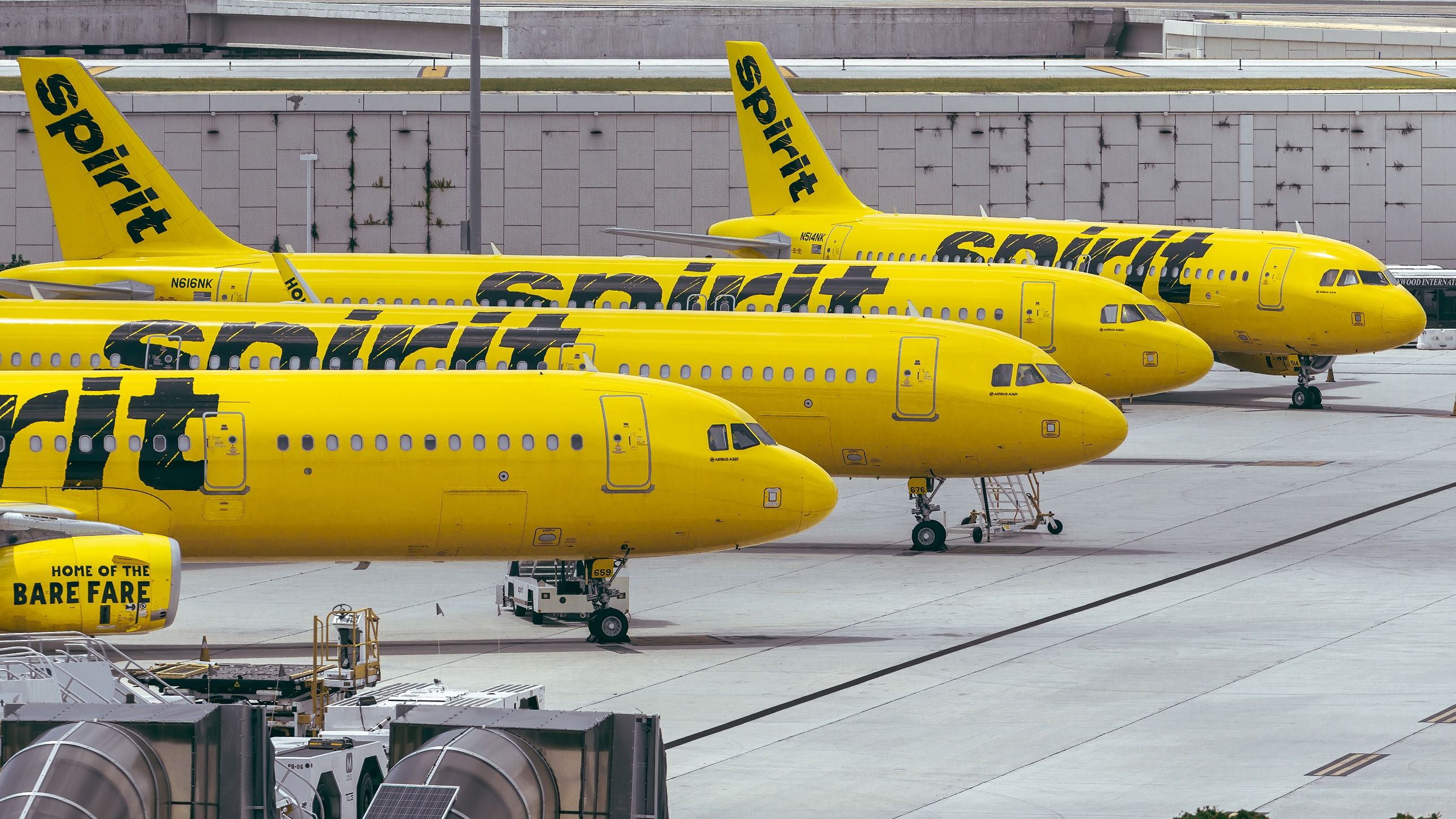 Several Spirit Airlines aircraft parked side by side on the apron at Fort Lauderdale Hollywood International Airport.