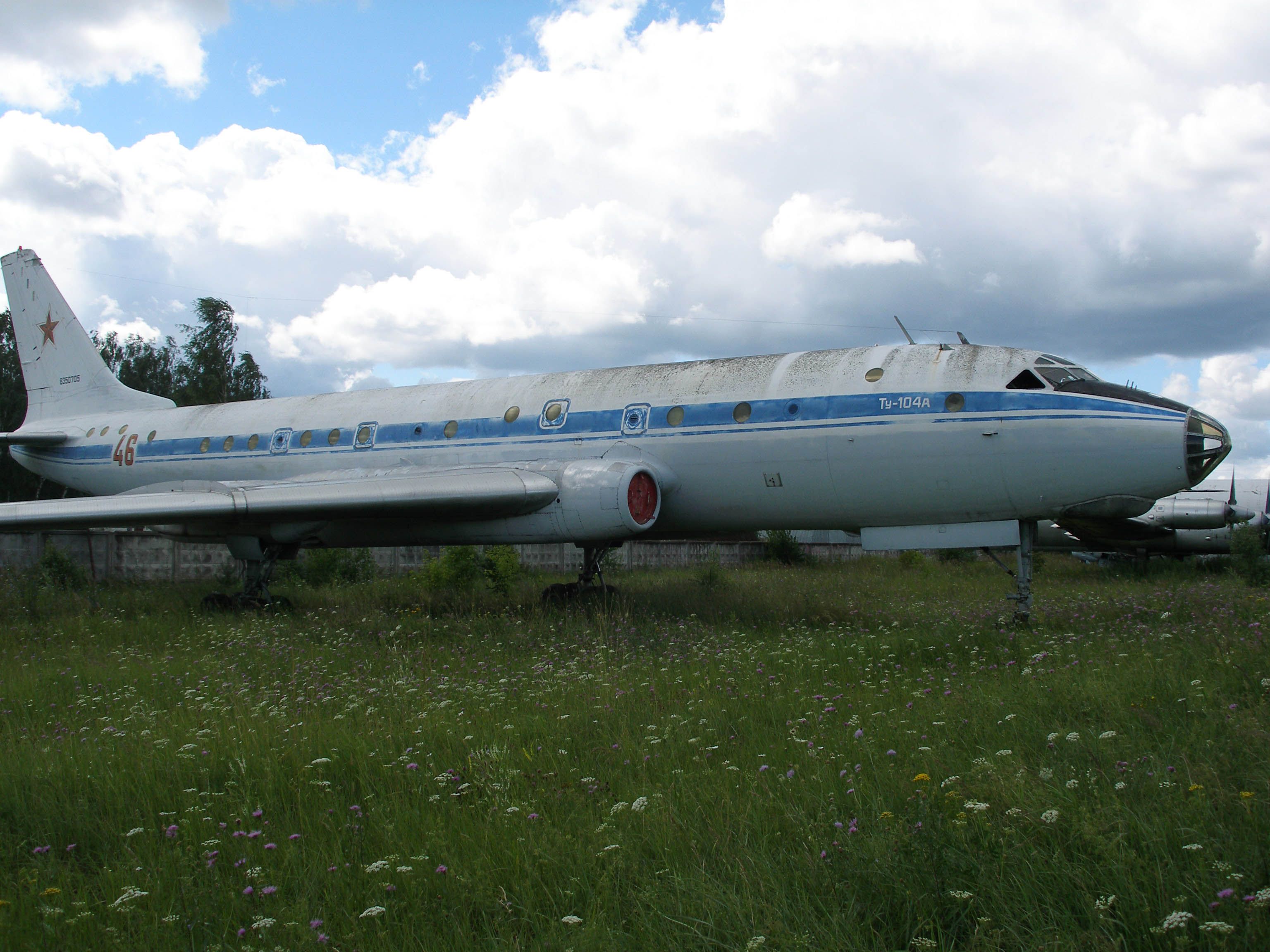 A Tupolev Tu-104 parked in a field.