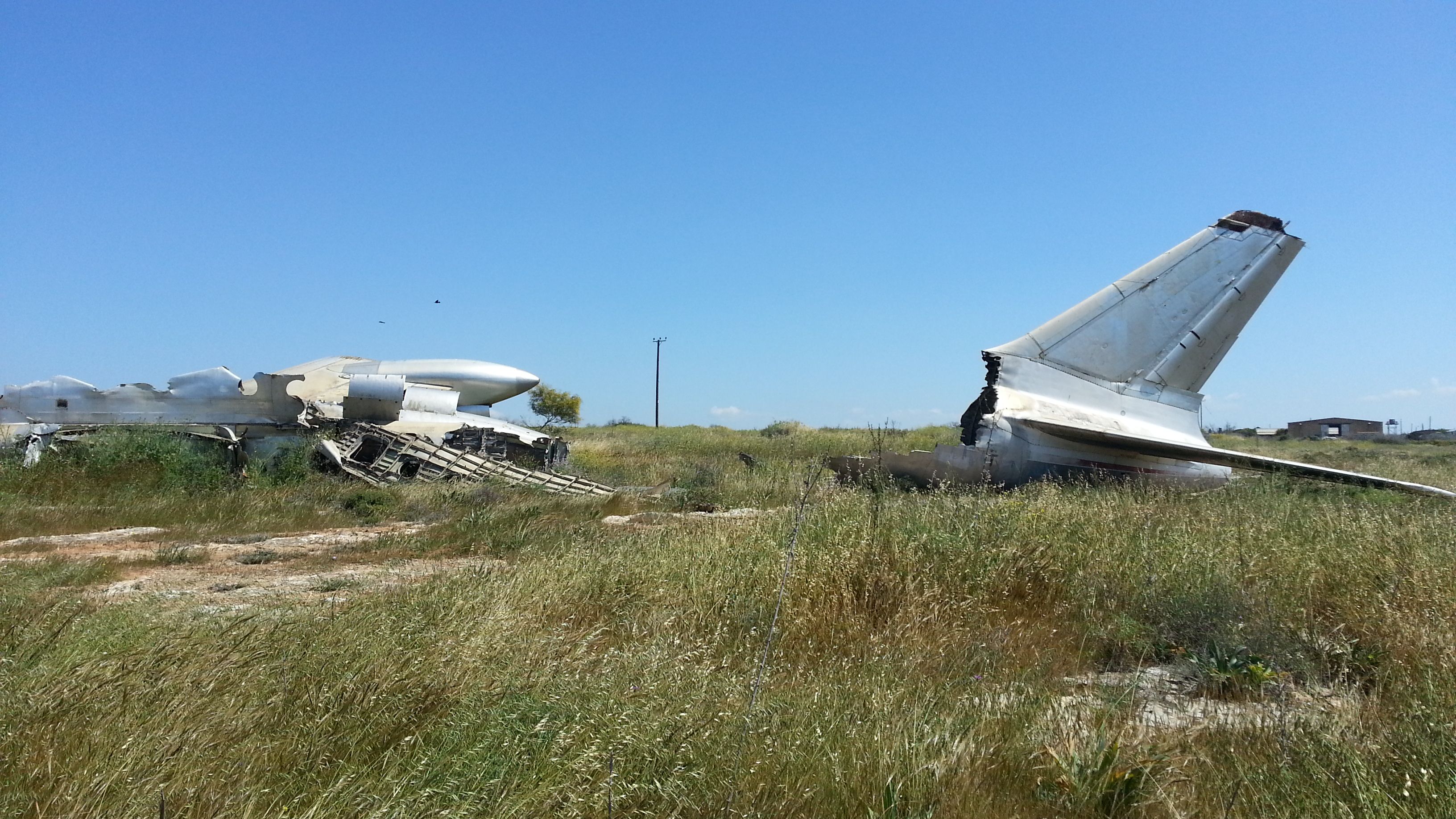A destroyed Tupolev Tu-104 in a field.