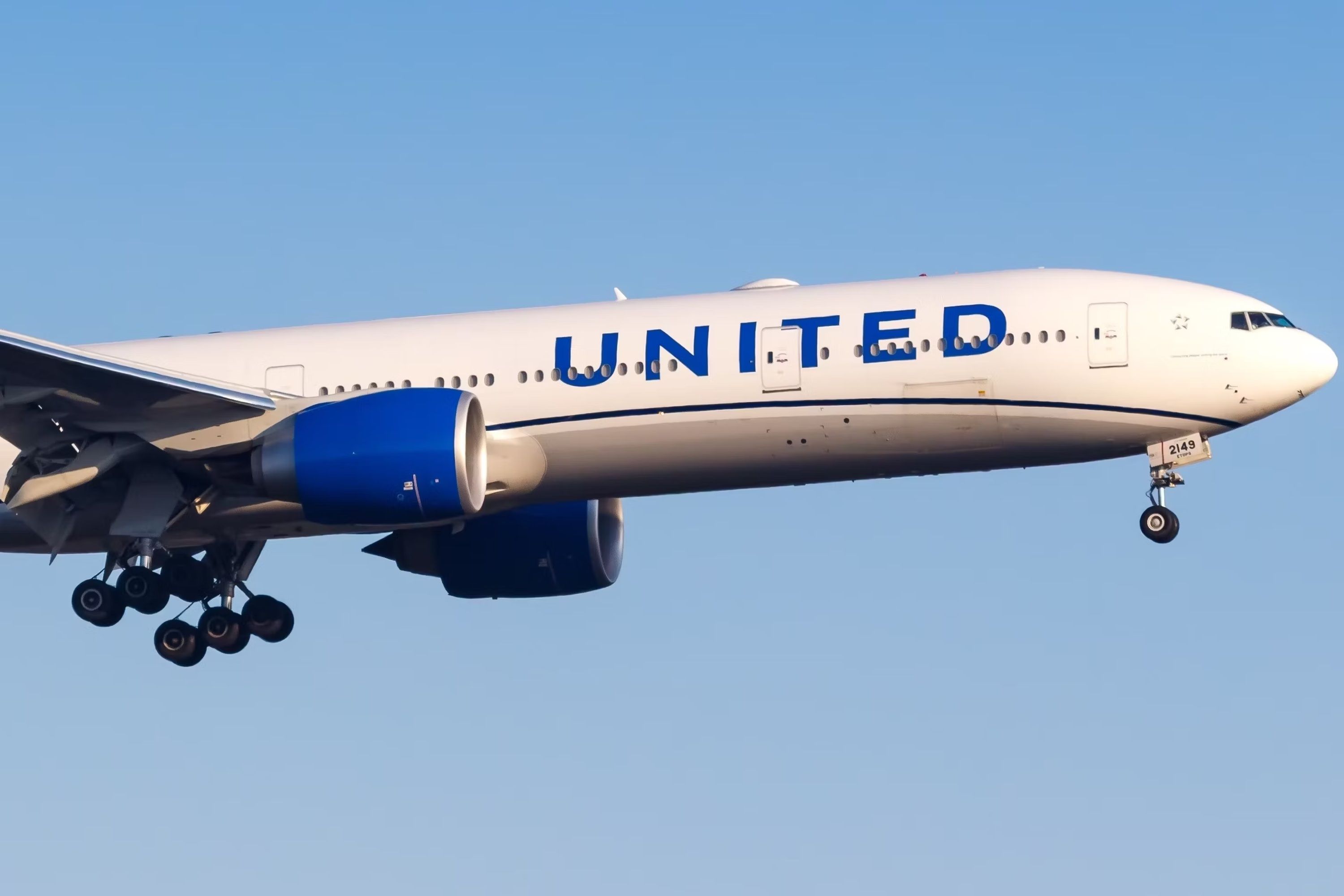 A United Airlines Boeing 777-300ER flying in the sky.