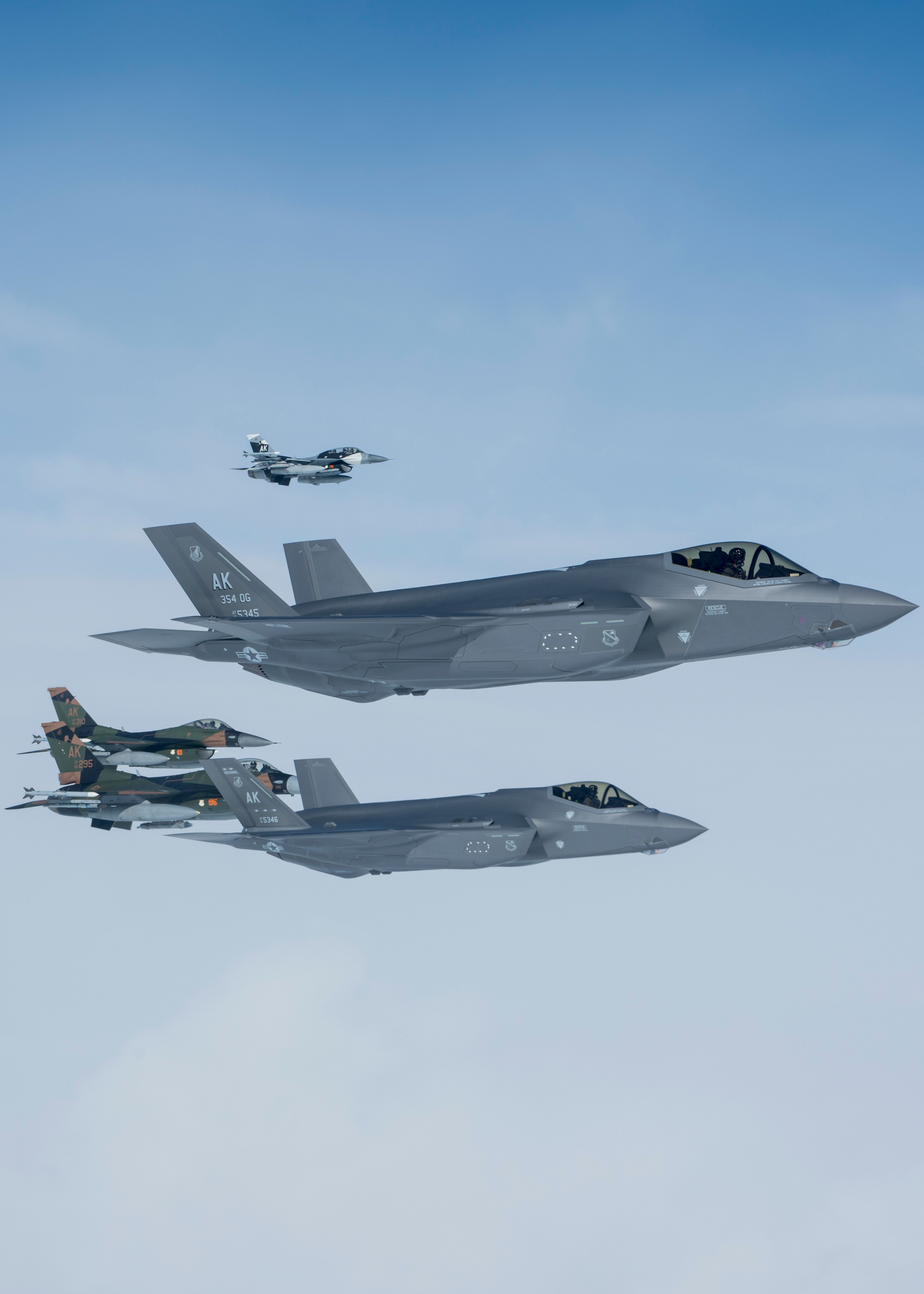 Two F-16C Fighting Falcons and two F-35A Lightning II aircraft from the 354th Fighter Wing, Eielson Air Force Base, Alaska, move into position to fly in formation off of a KC-135R Stratotanker from the 168th Wing, Alaska Air