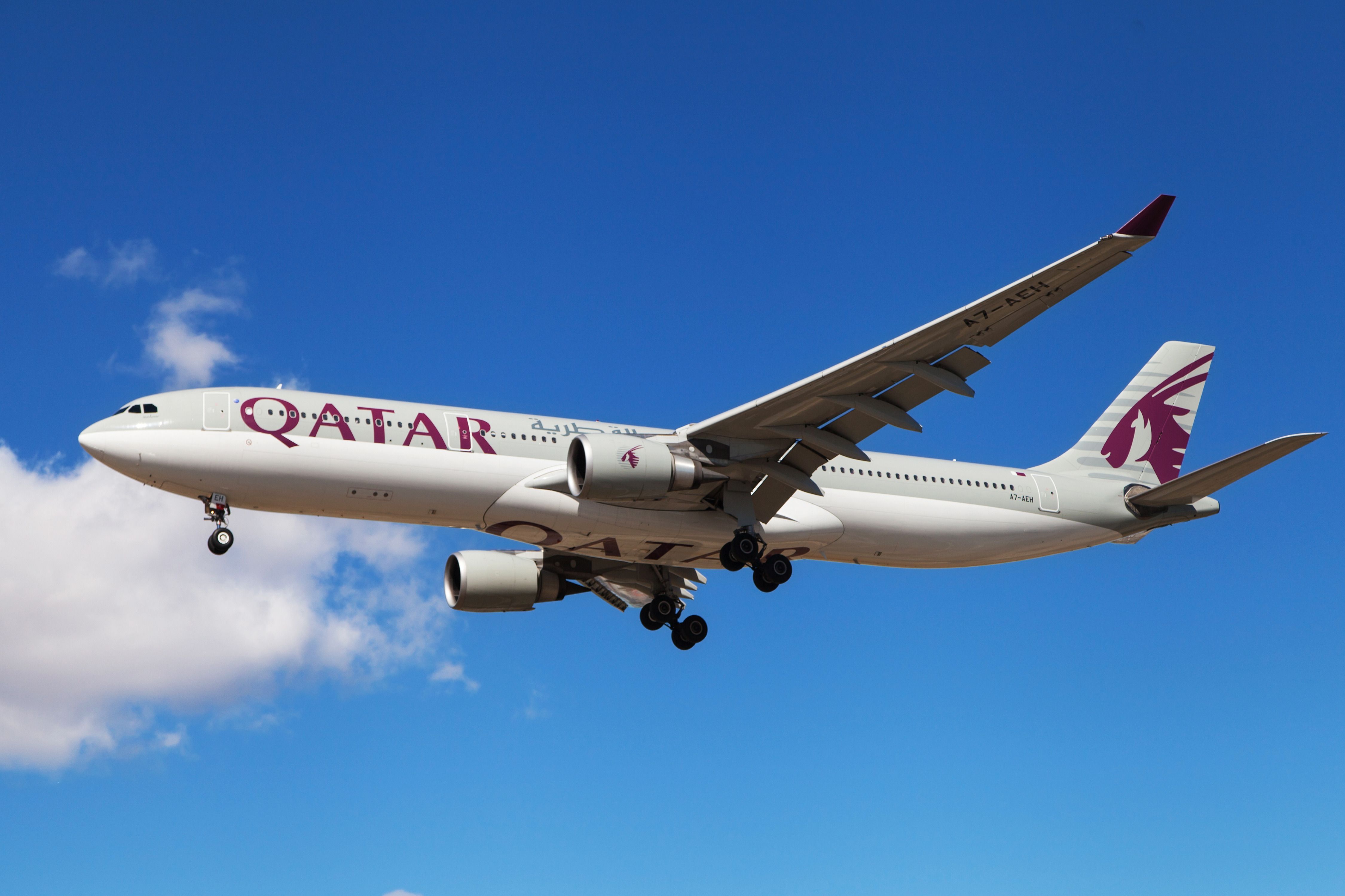A Qatar Airways aircraft flying in the sky. 