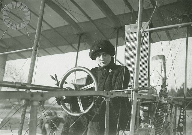A portrait of Raymonde de Laroche in the cockpit of a first generation aircraft.