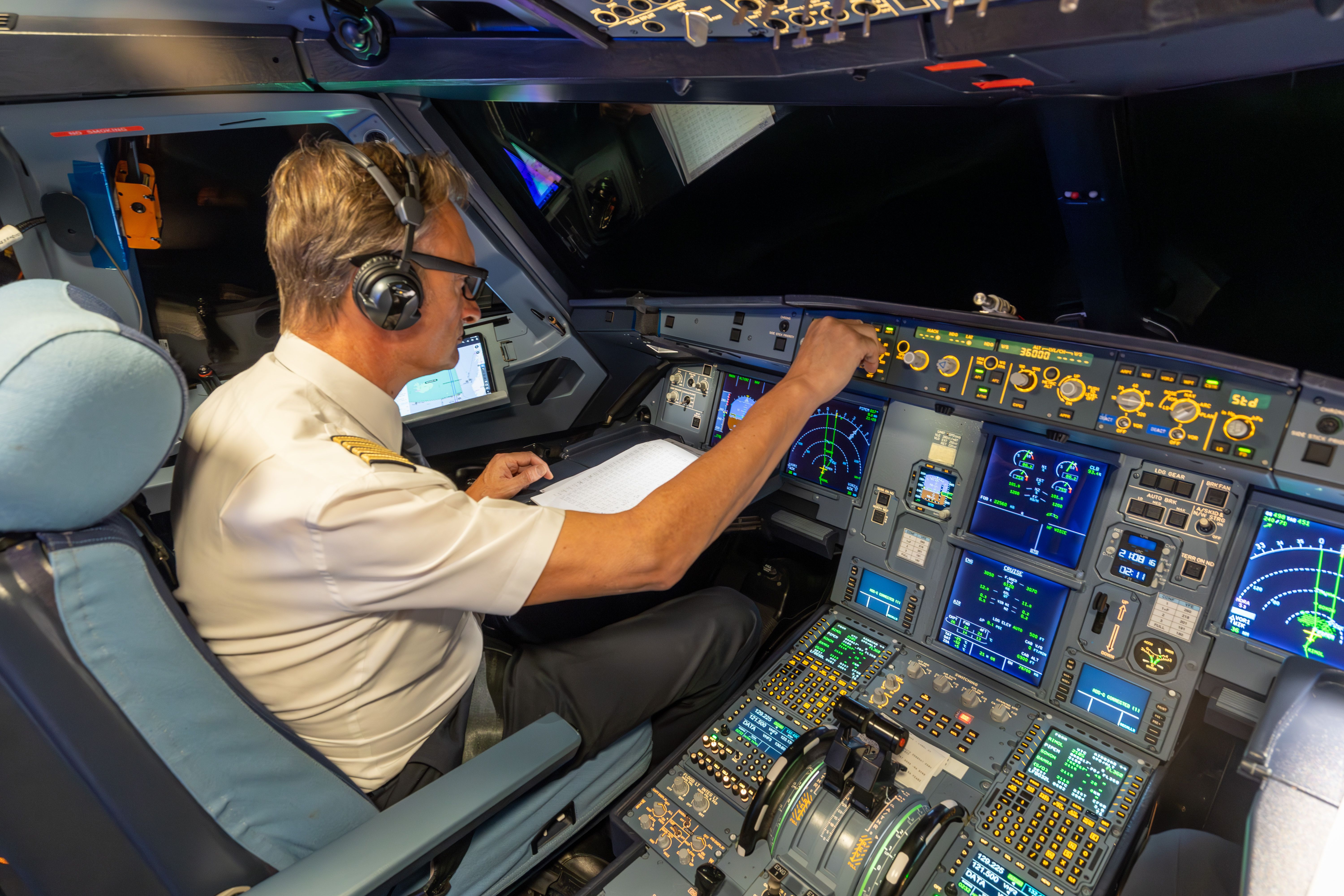 A pilot in the cockpit of an Airbus A320.