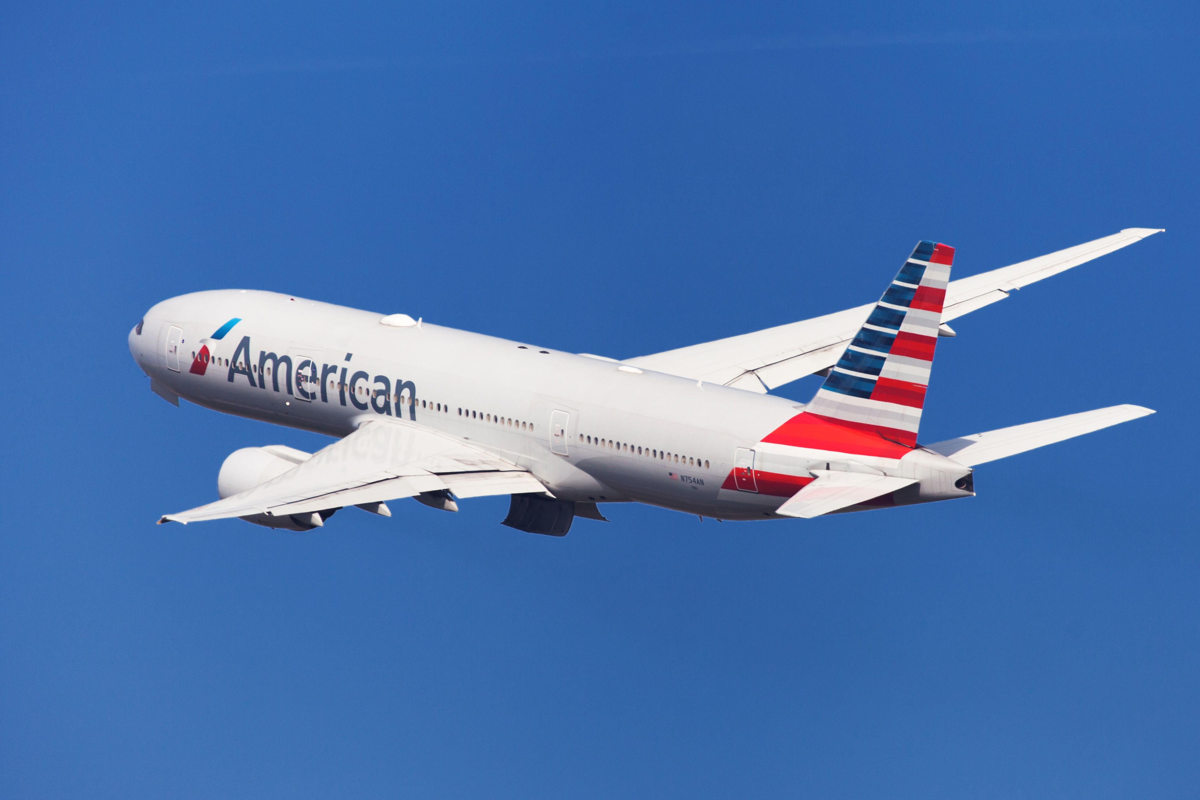 An American Airlines Boeing 777-200ER flying in the sky.