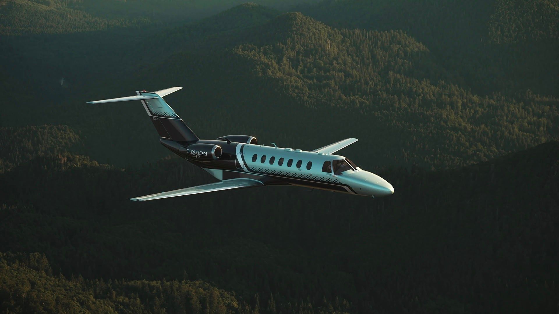 A Cessna Citation CJ3 Gen2 flying over land.