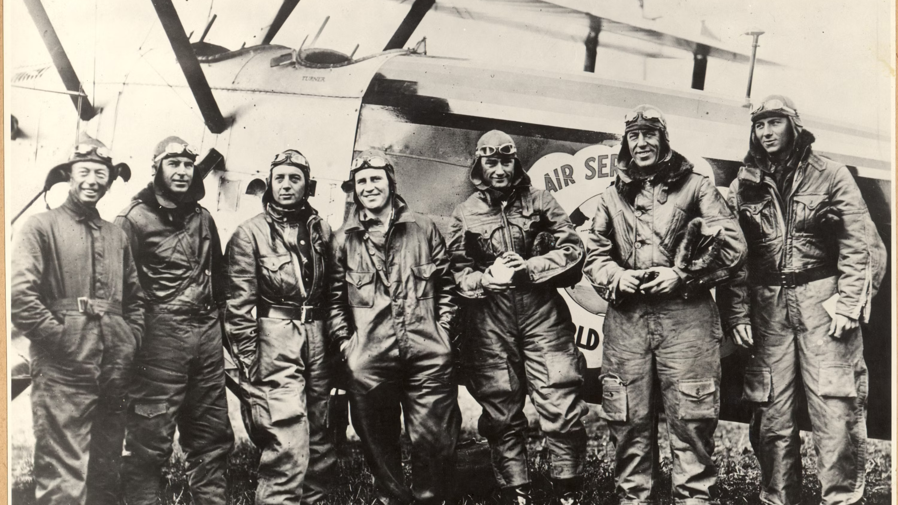 Several Air crew members from several nations standing near an aircraft.