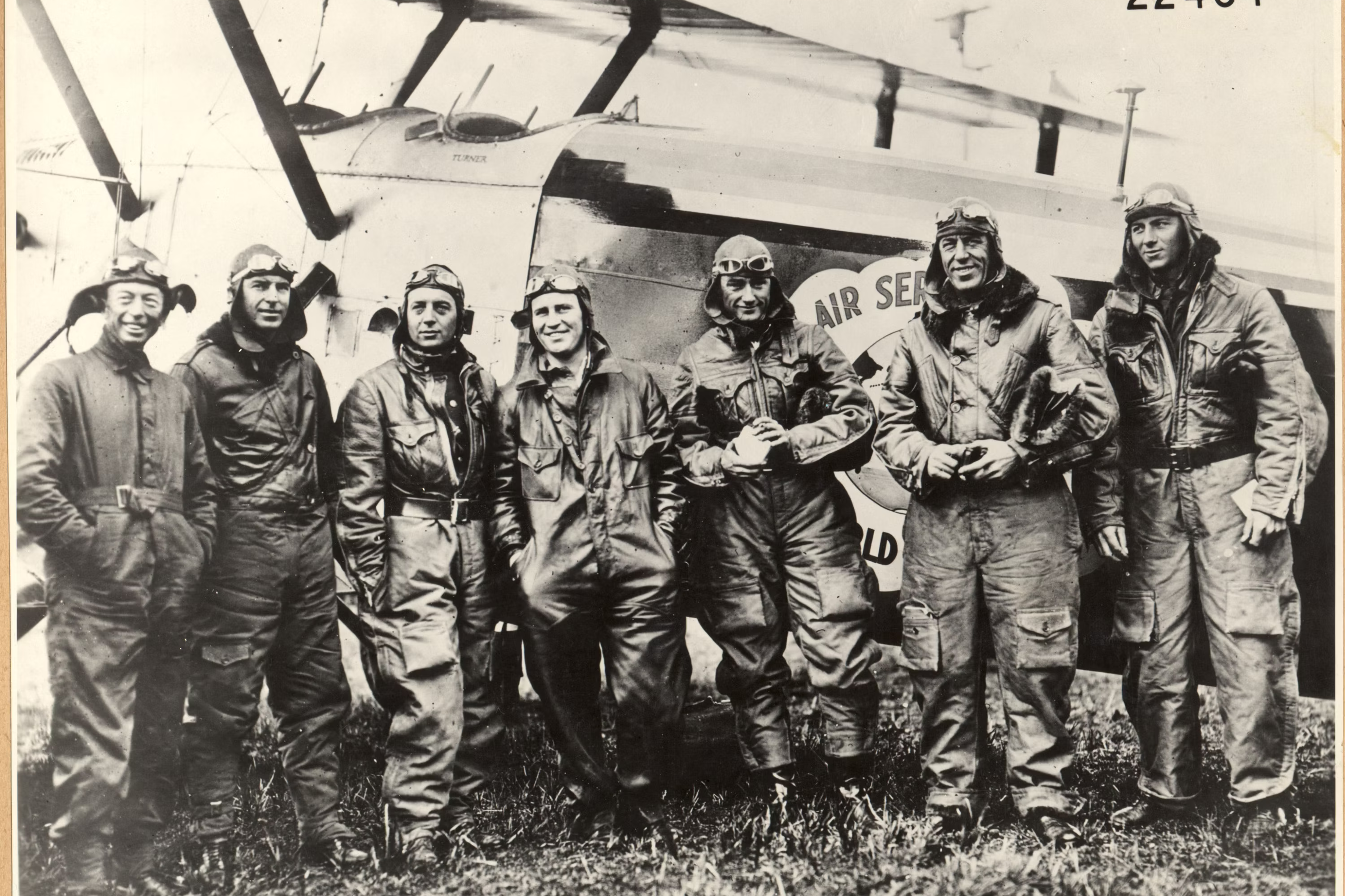 Several Air crew members from several nations standing near an aircraft.