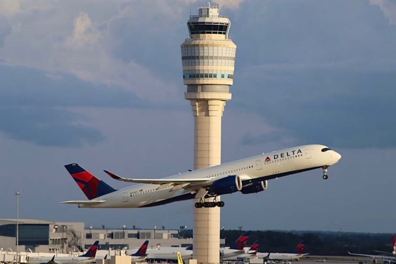 Delta aircraft flying past control tower at Atlanta Airport