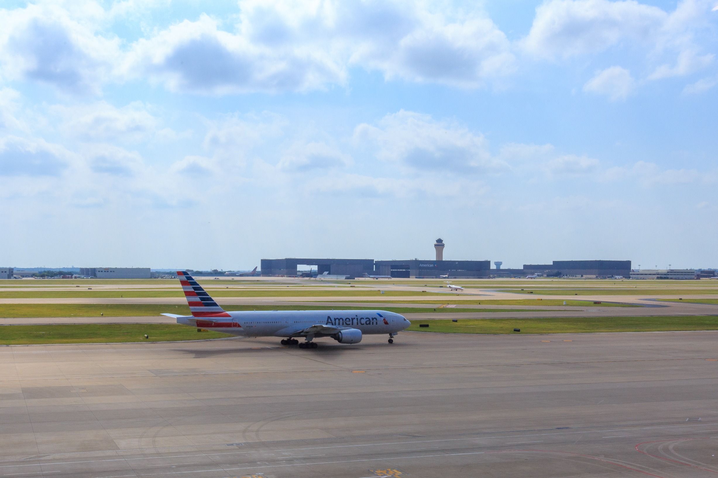 An American Airlines 777-200 flanked by a westerly from at DFW. 