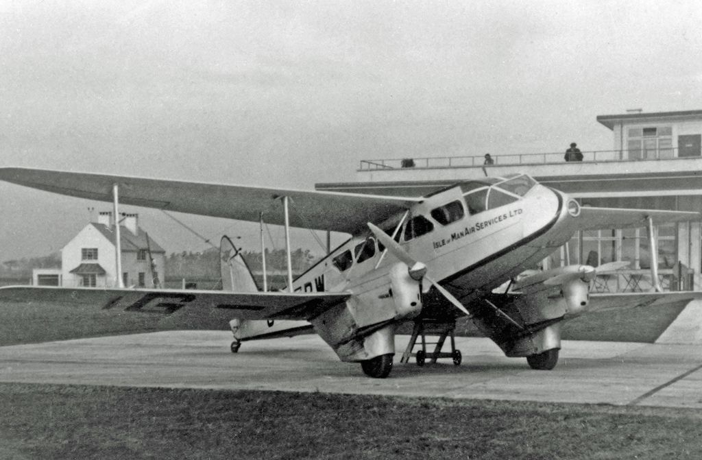 An Isle Of Man Air Services De Havilland Dragon Rapide parked on an airport apron.
