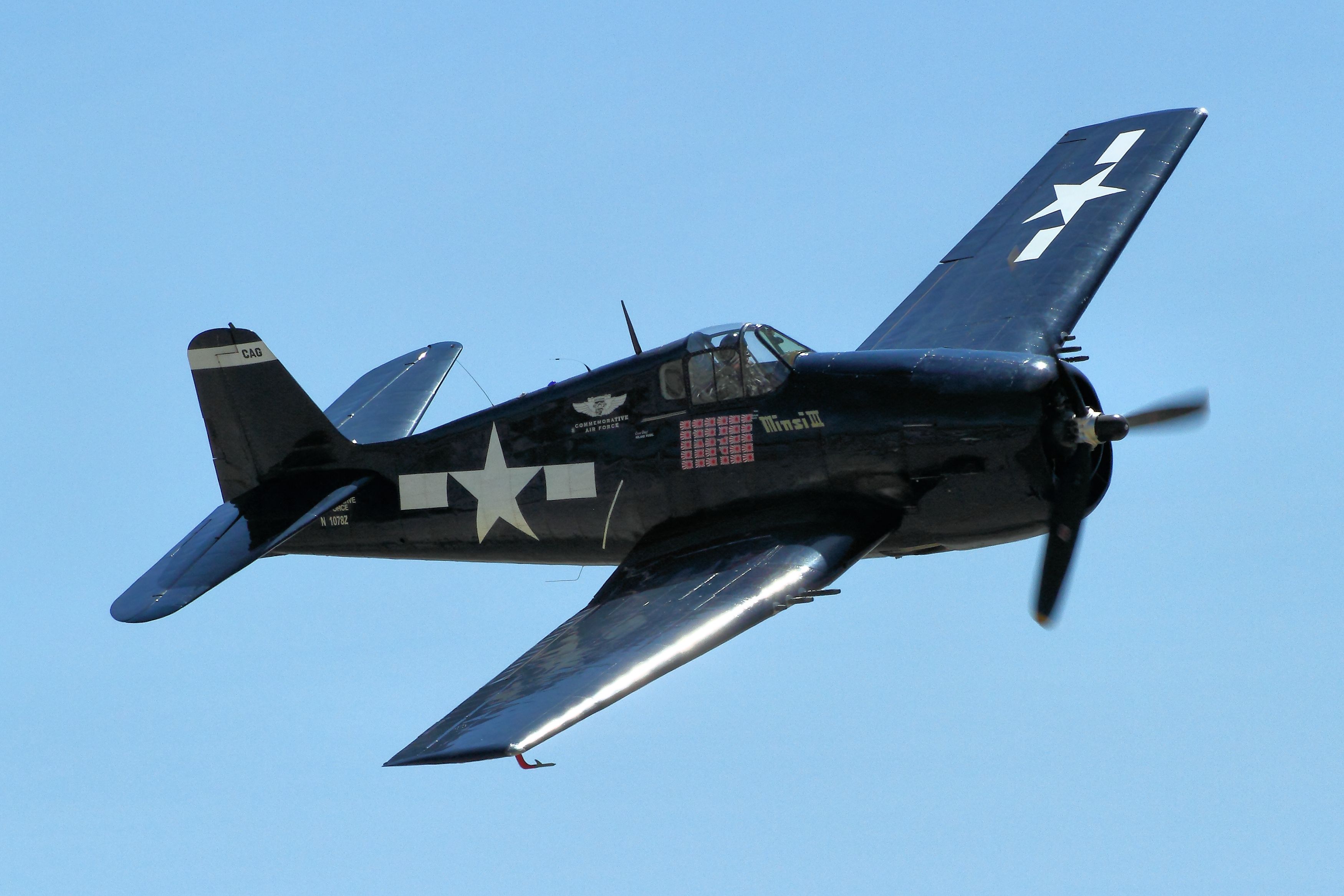 A Grumman F6F Hellcat flying in the sky.