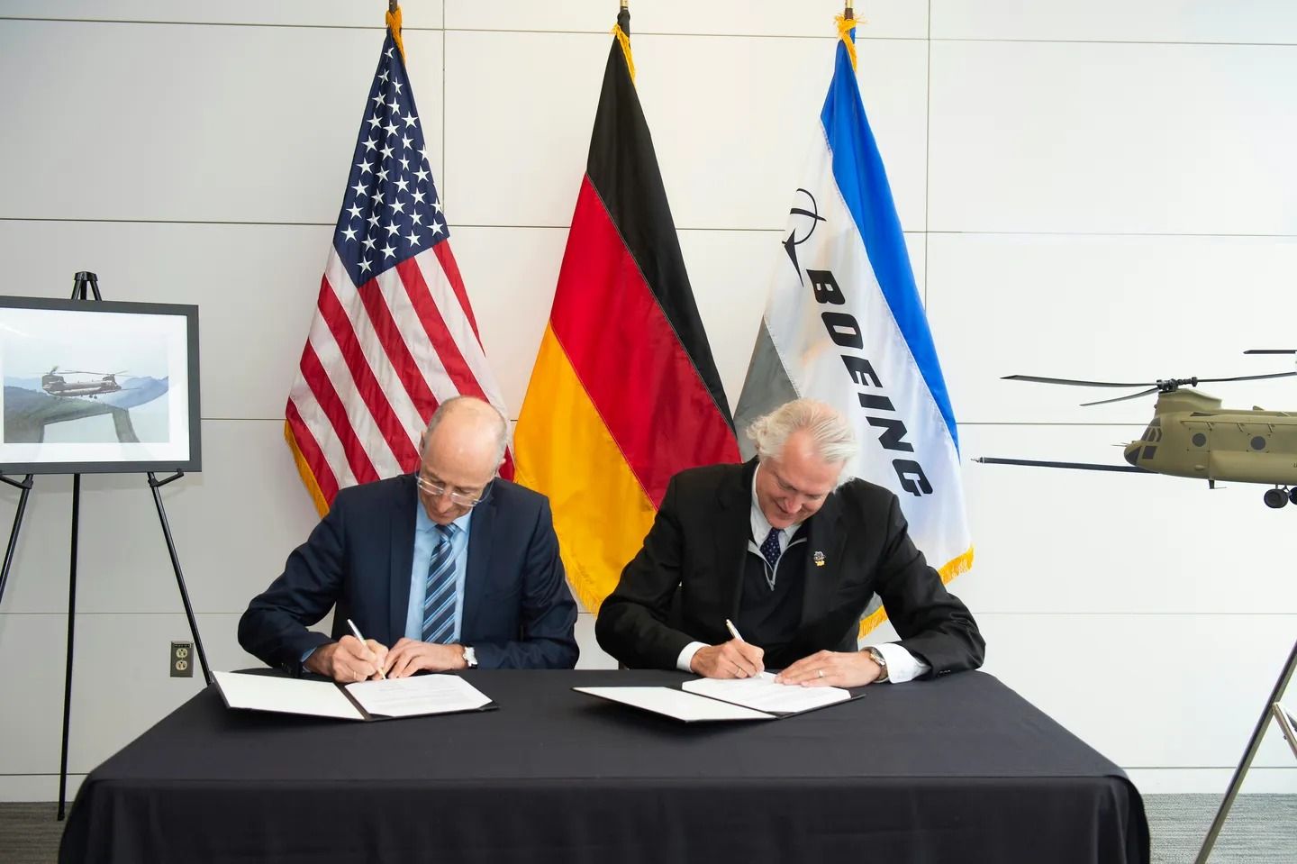 Representatives from Airbus and Boeing signing a partnership related to the Chinook.