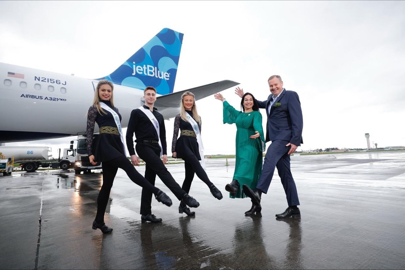 Five individuals stand near a JetBlue aircraft on the apron in Dublin.