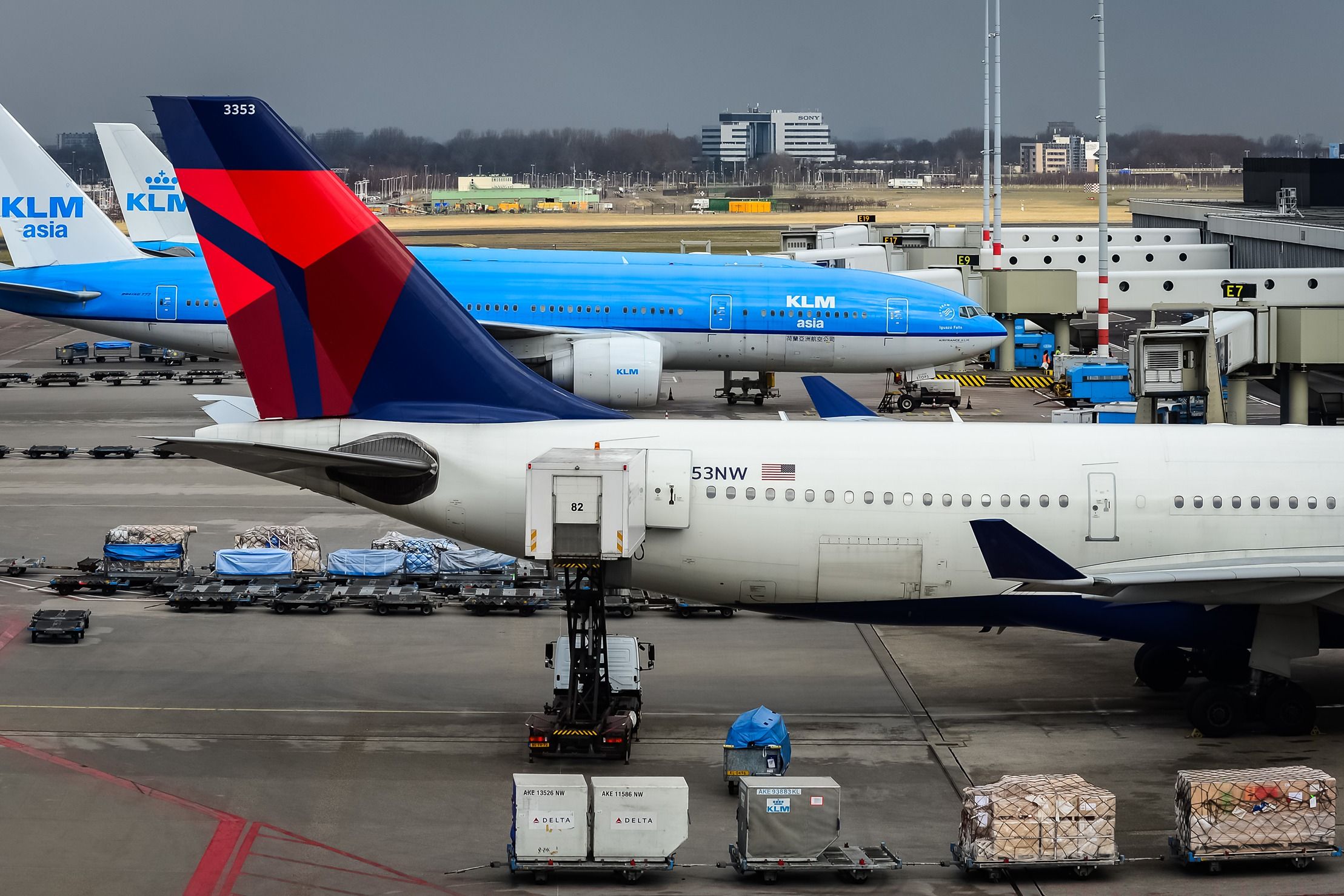 KLM and Delta Air Lines aircraft parked on the apron at Amsterdam Schiphol Airport.