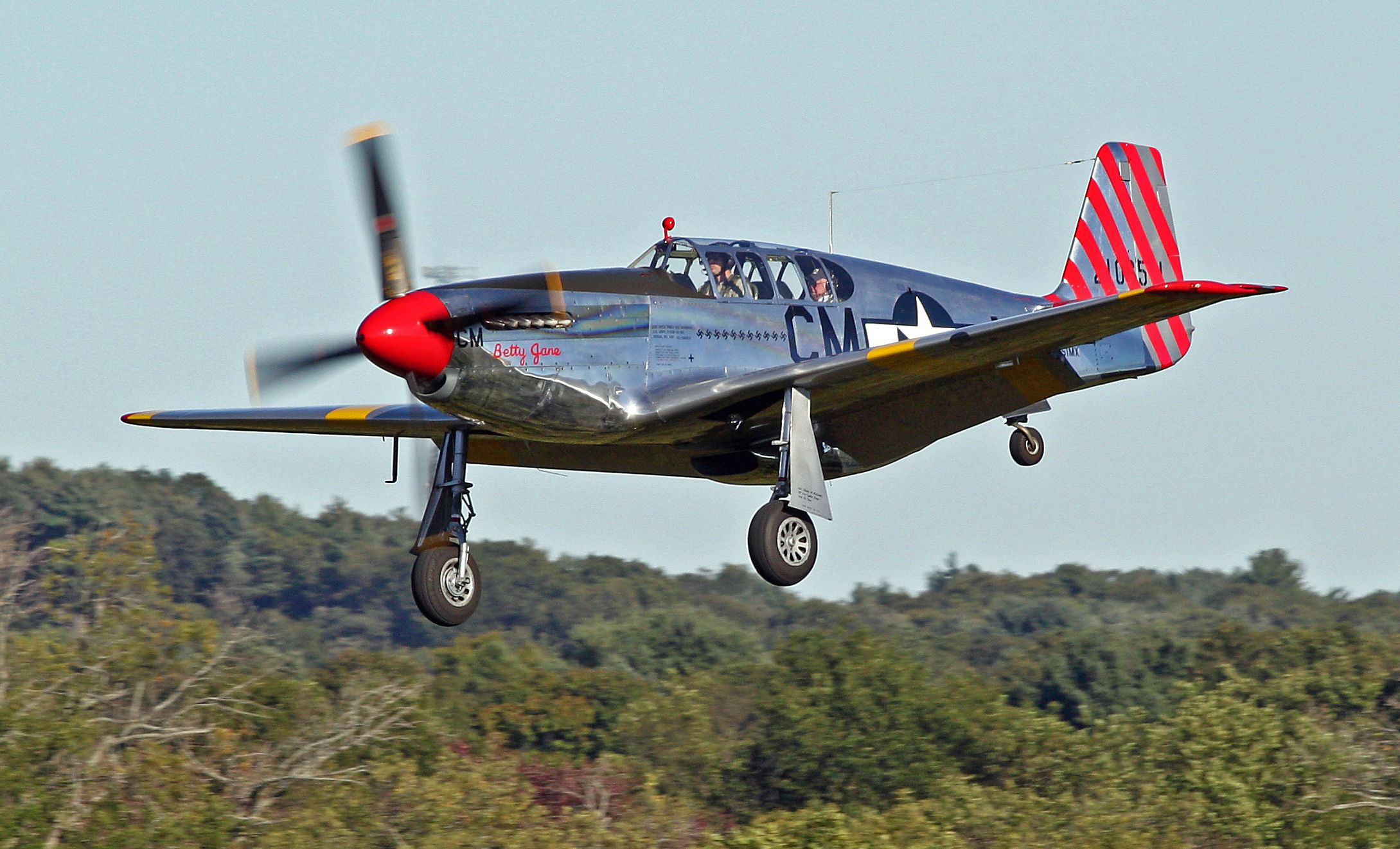 A P-51C Mustang flying in the sky.