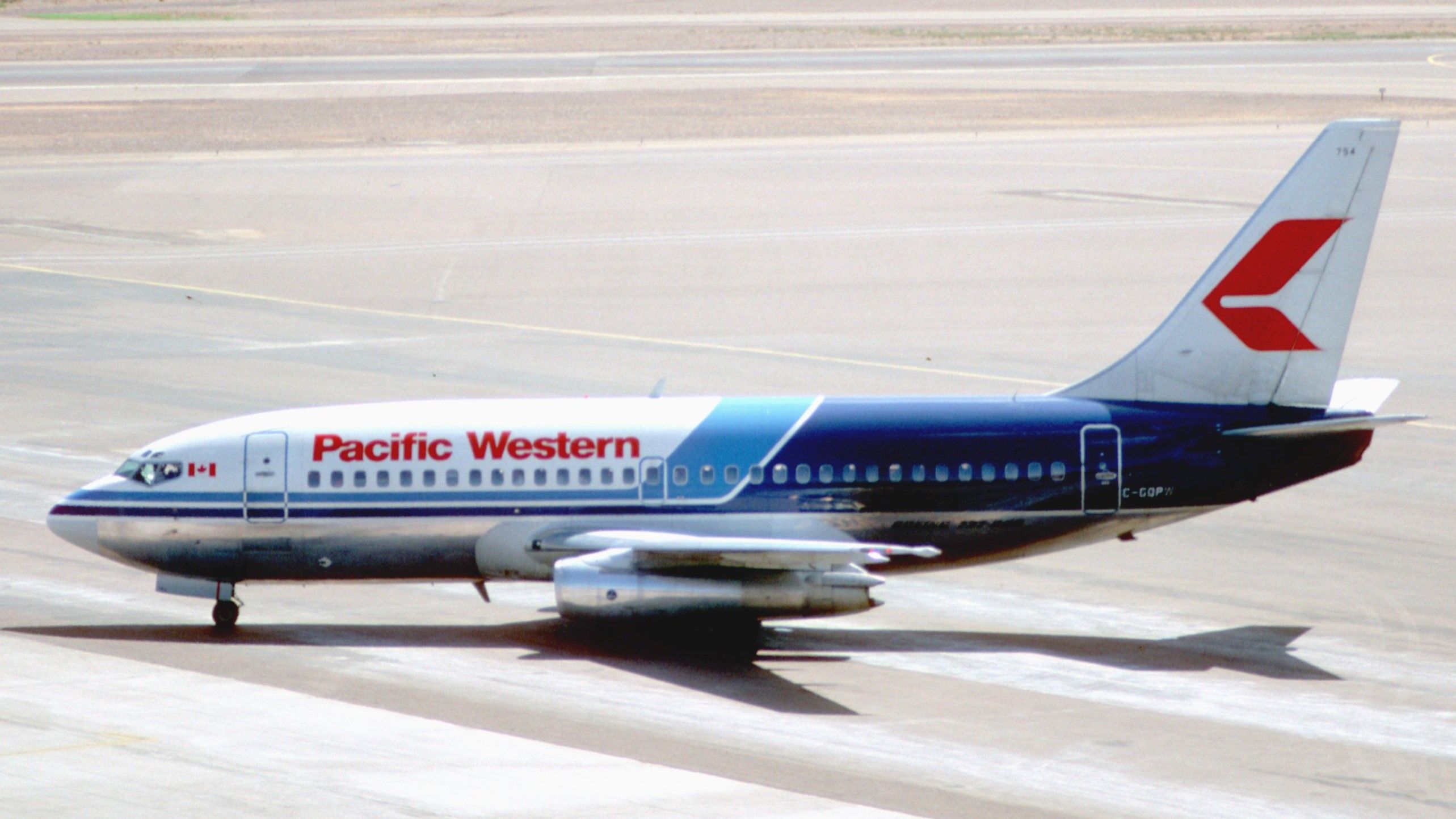 A Pacific Western Airlines Boeing 737-200 on an airport apron.