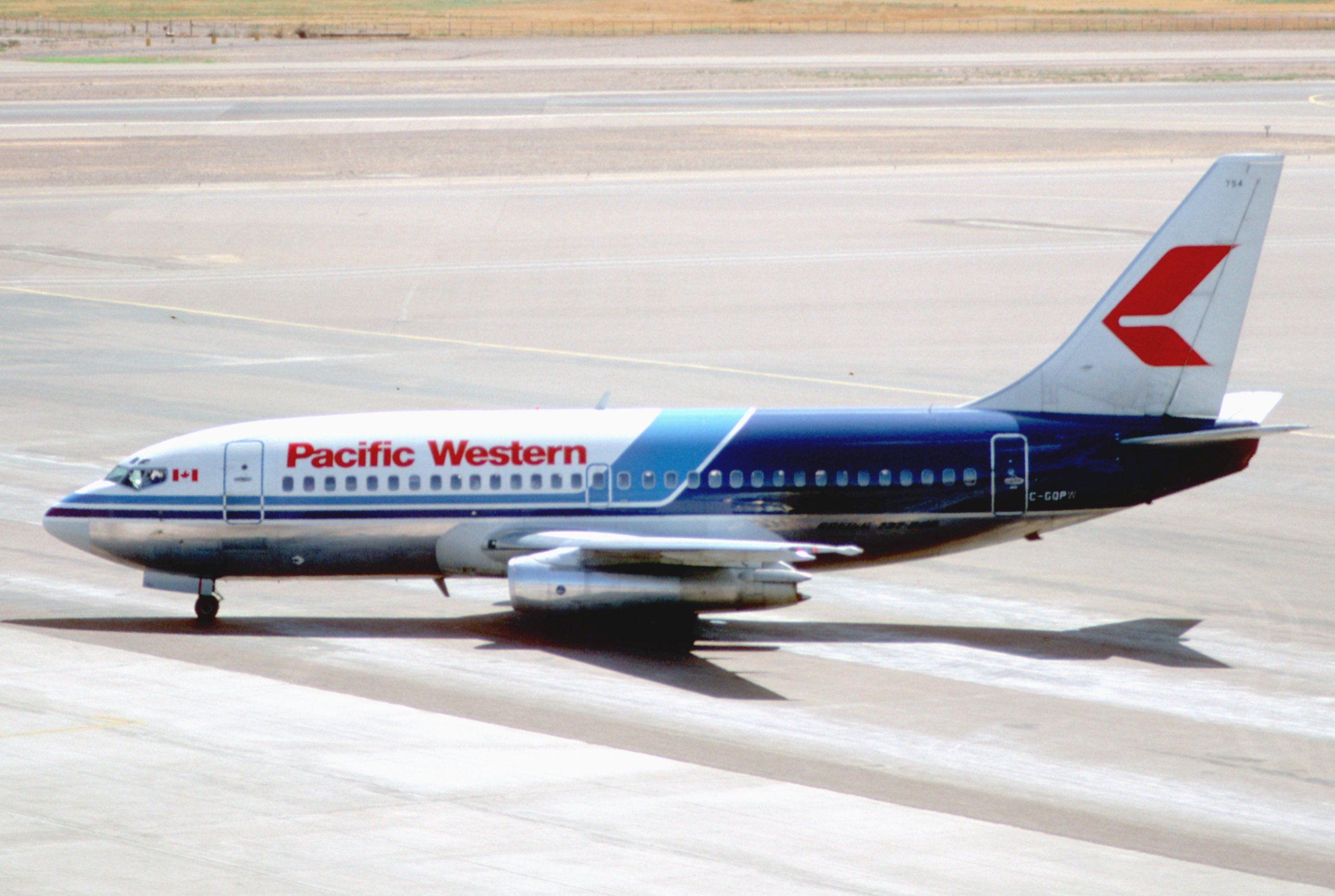 A Pacific Western Airlines Boeing 737-200 on an airport apron.