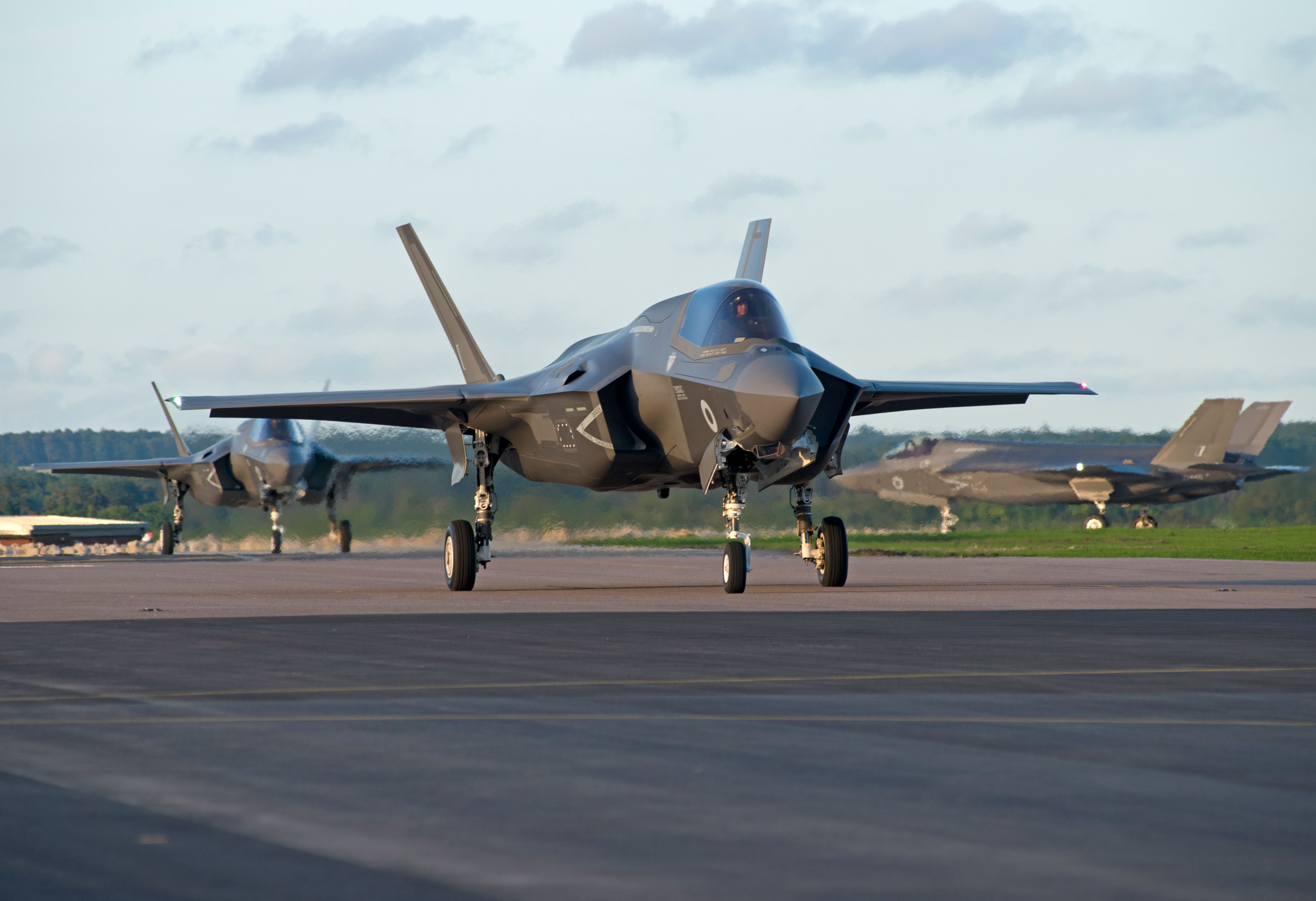 Three F-35Bs on an airfield apron.