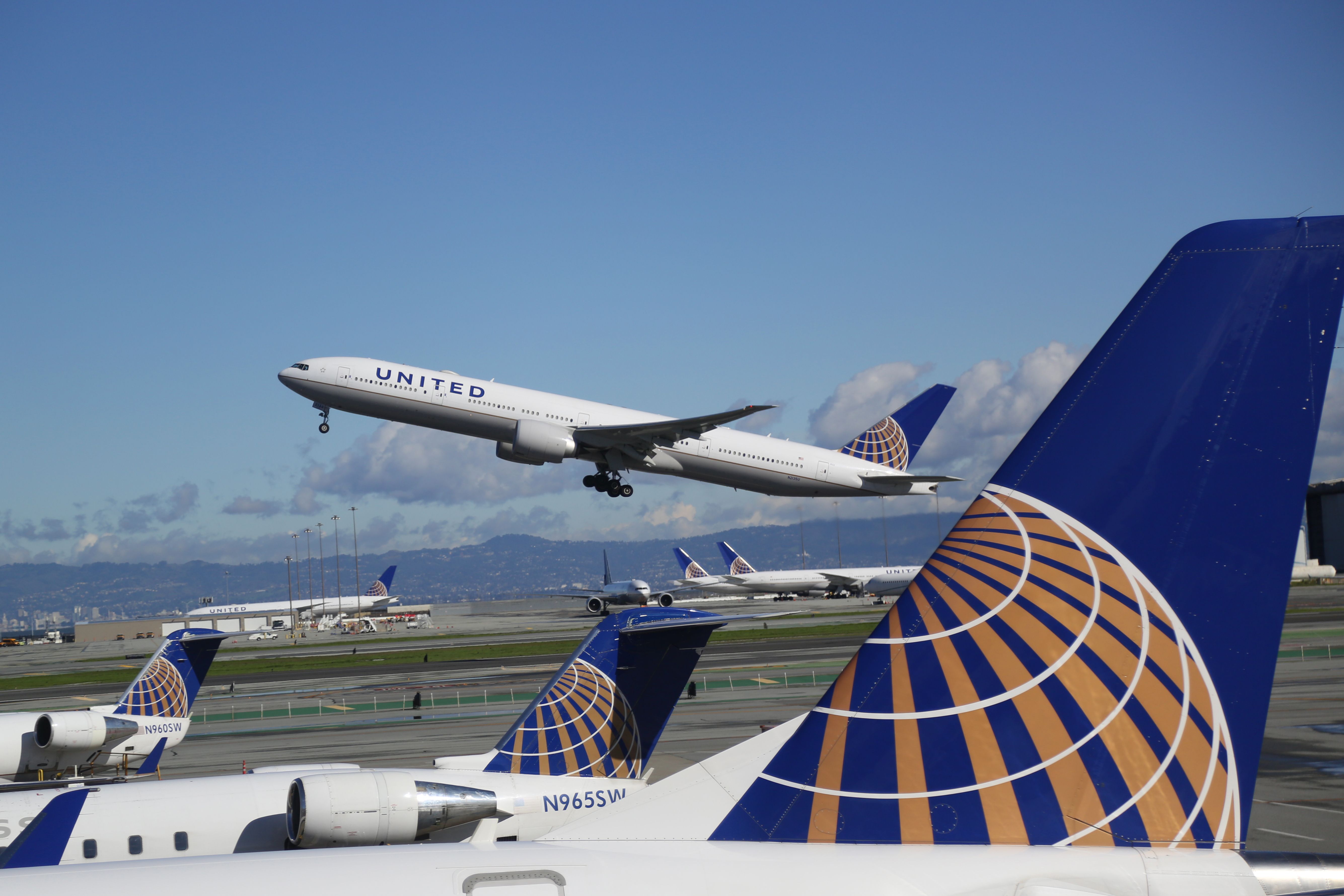 A United Airlines aircraft taking off while several others are parked on the apron.