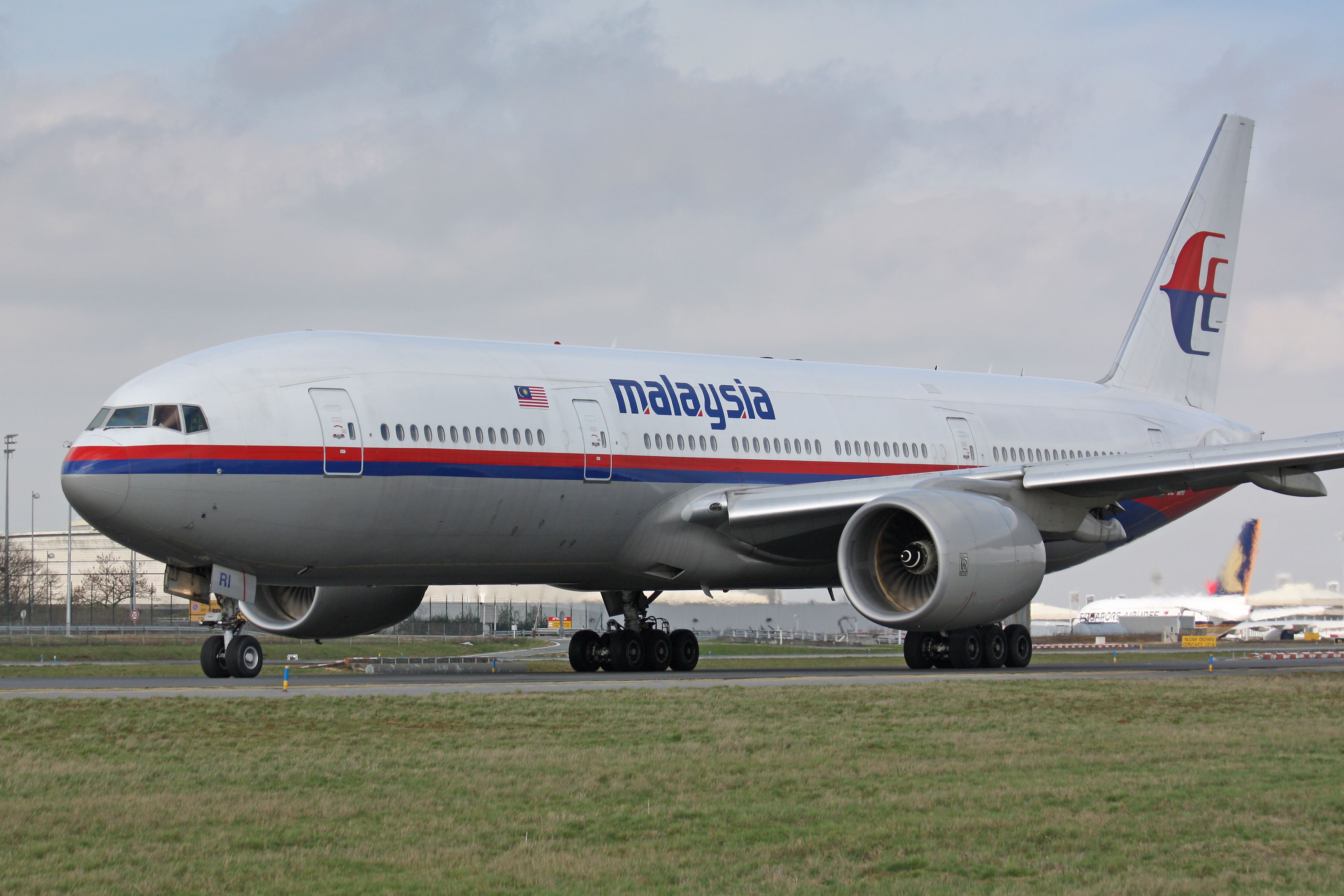 A Malaysia Airlines Boeing 777 on an airport apron.