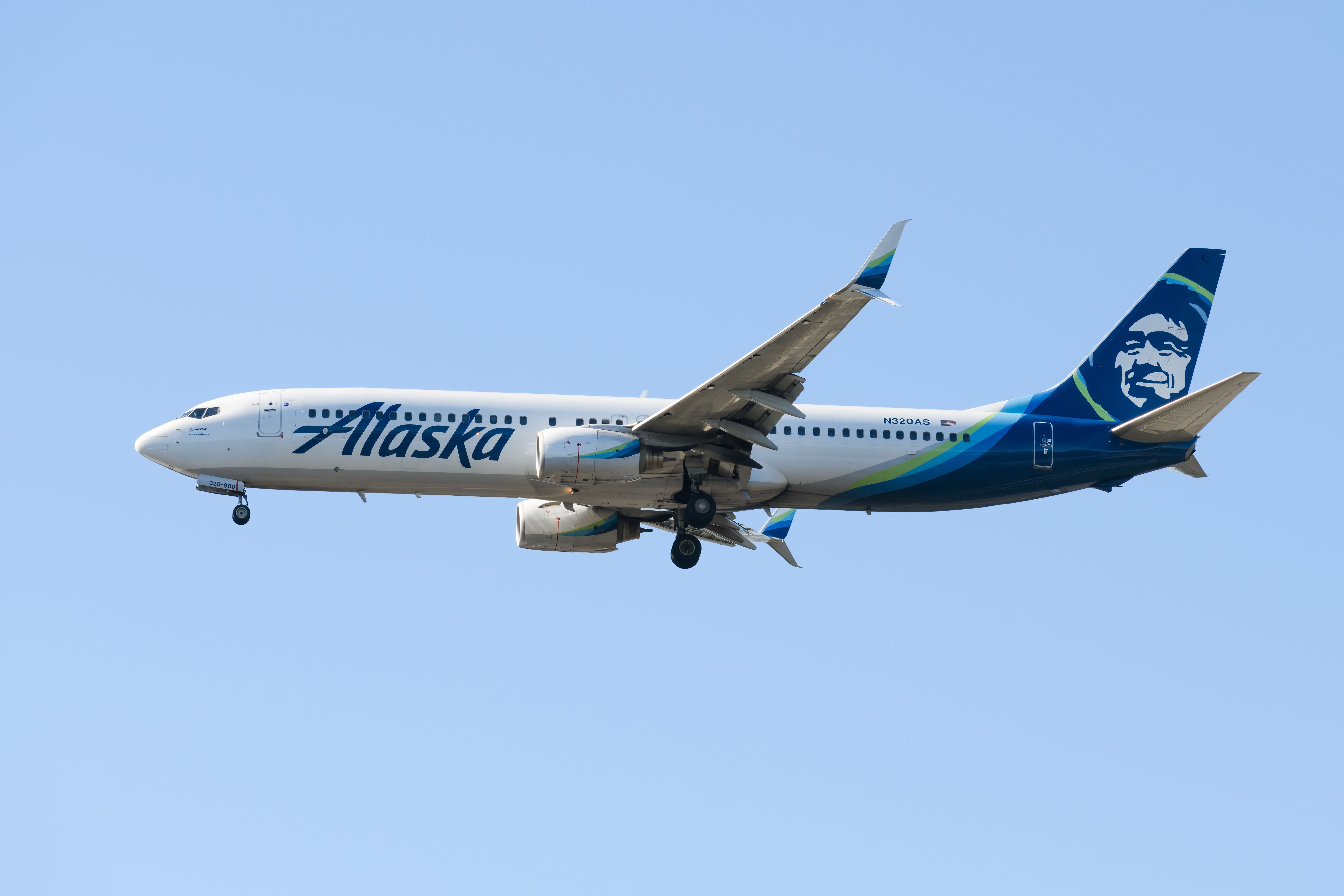 An Alaska Airlines Boeing 737-900 flying in the sky.